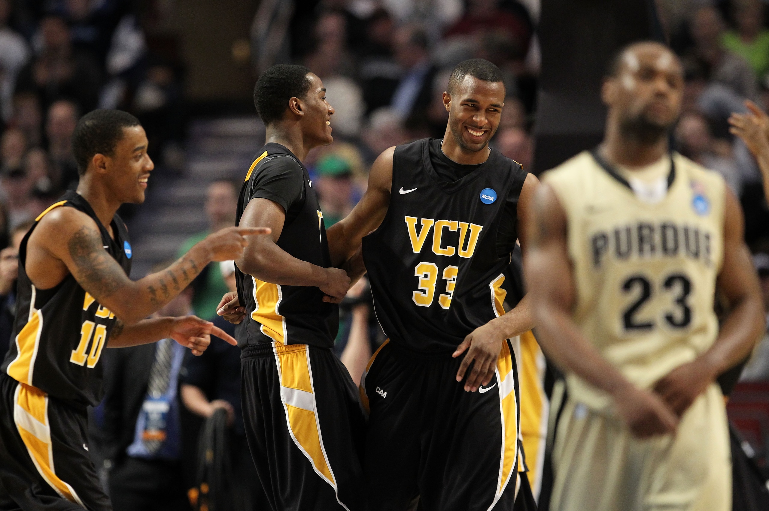 CHICAGO, IL - MARCH 20:  Rob Brandenberg #23, D.J. Haley #33 and Darius Theus #10 of the Virginia Commonwealth Rams celebrate their win as Lewis Jackson #23 of the Purdue Boilermakers walks off the court in the second half during the third round of the 20