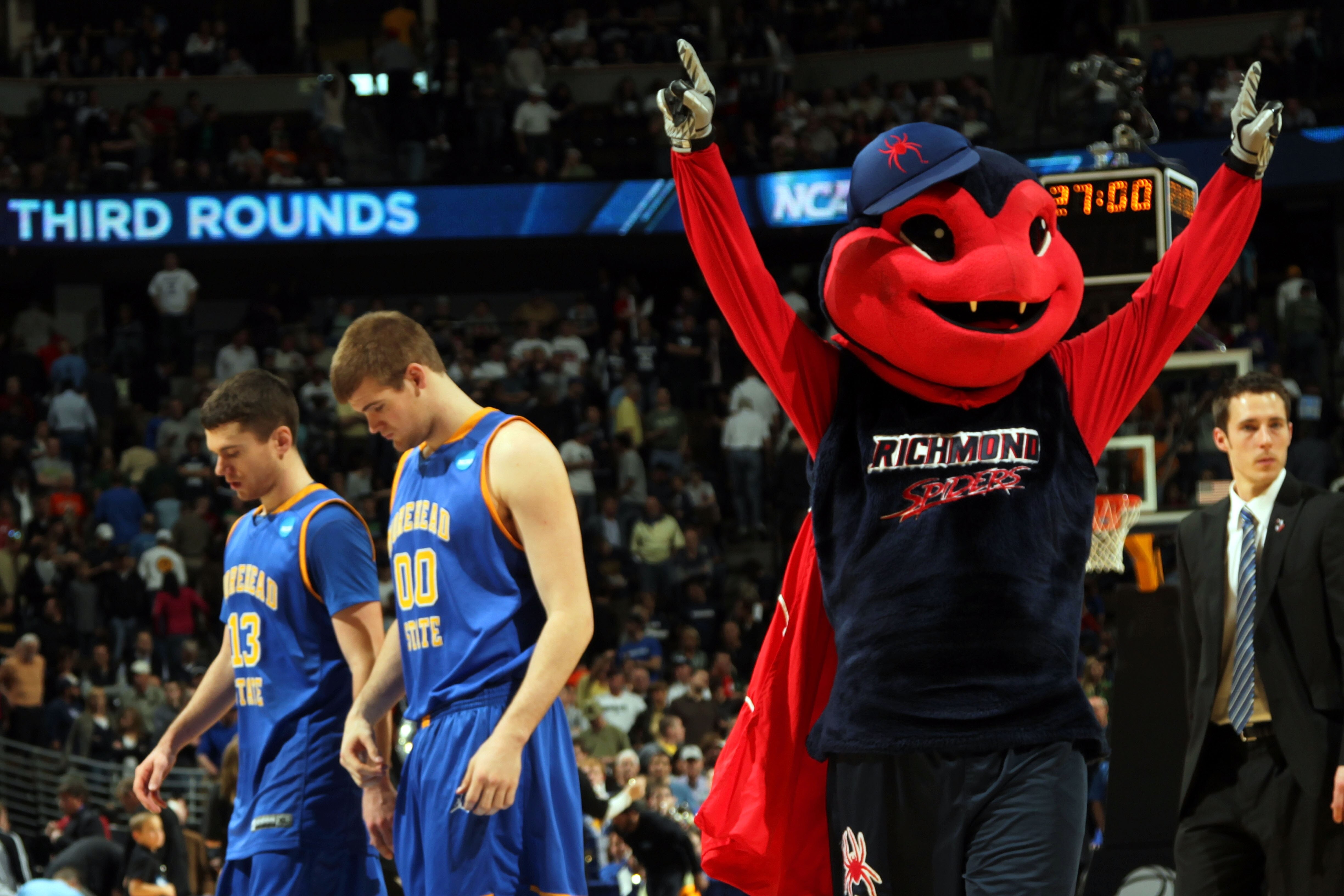 DENVER, CO - MARCH 19:  The Richmond Spiders mascot celebrates after the game as Ty Proffitt #13 and Drew Kelly #00 of the Morehead State Eagles walk off the court during the third round of the 2011 NCAA men's basketball tournament at Pepsi Center on Marc