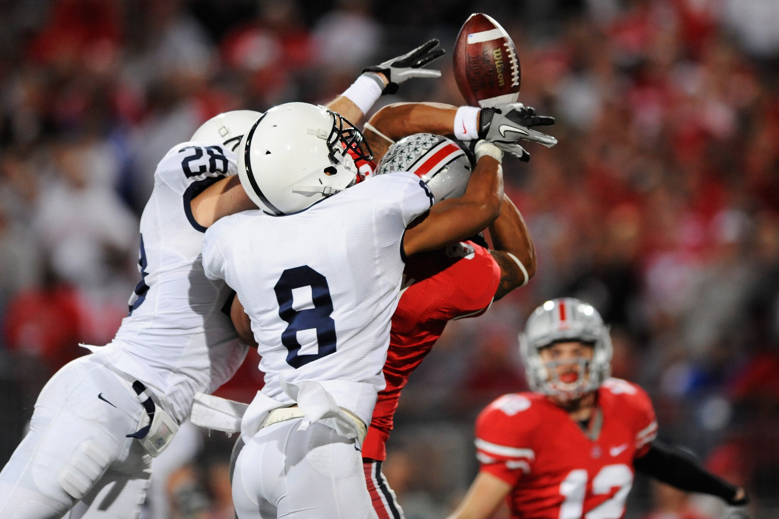 COLUMBUS, OH - NOVEMBER 13:  Drew Astorino #28 and D'Anton Lynn #8, both of the Penn State Nittany Lions, break up a pass intended for DeVier Posey #8 of the Ohio State Buckeyes as Dane Sanzenbacher #12 of the Ohio State Buckeyes waits nearby to make the