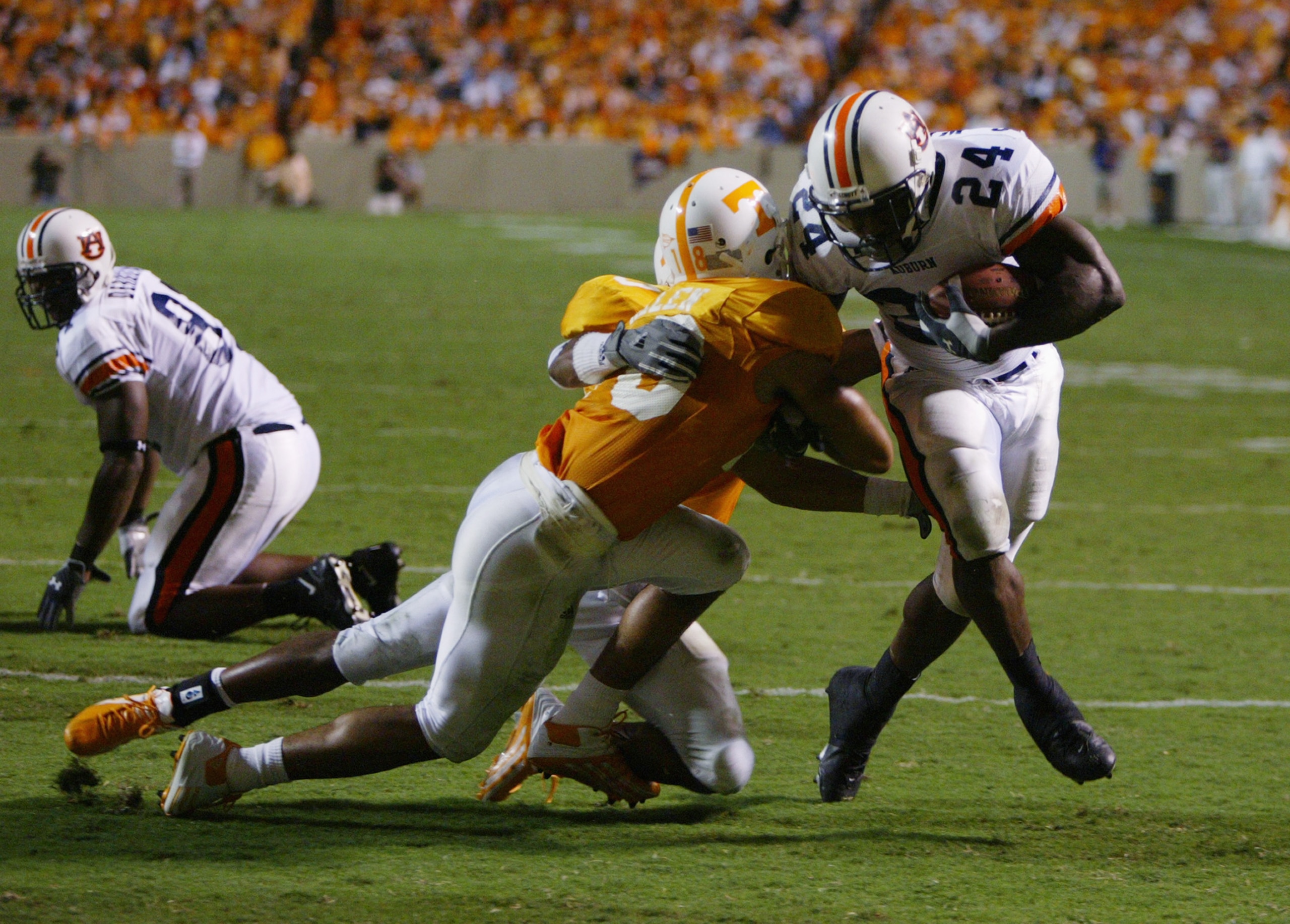 KNOXVILLE, TN - OCTOBER 2:  Running back Carnell Williams #24 of the Auburn Tigers tries to break the tackle attempt of defensive back Jason Allen #18 of the Tennessee Volunteers at Neyland Stadium on October 2, 2004 in Knoxville, Tennessee. Auburn defeat