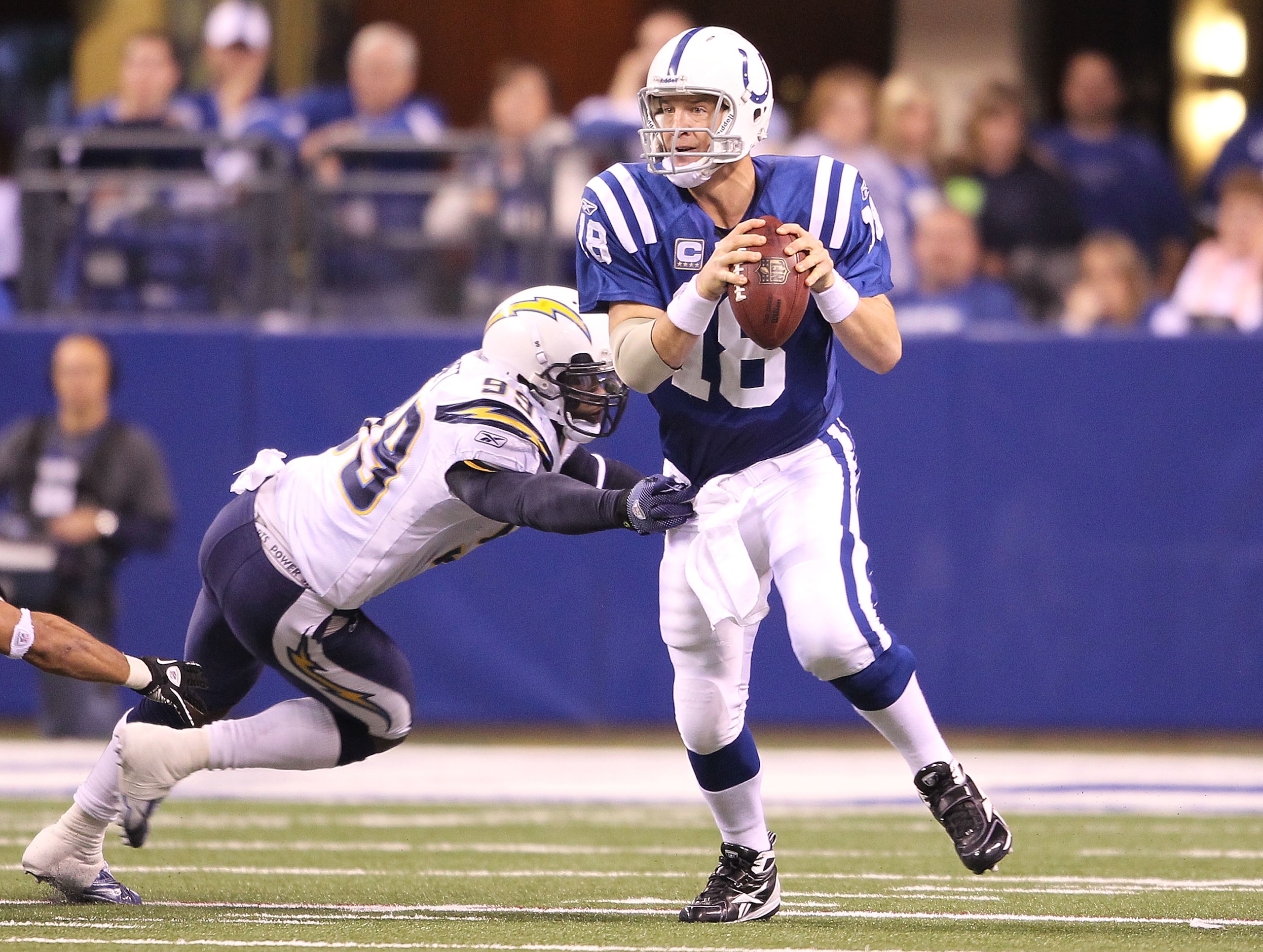 INDIANAPOLIS - NOVEMBER 28:  Peyton Manning #18 of the Indianapolis Colts looks to throw a pass while pursued by Kevin Burnett #99 of the San Diego Chargers during the NFL game at Lucas Oil Stadium on November 28, 2010 in Indianapolis, Indiana.  The Charg