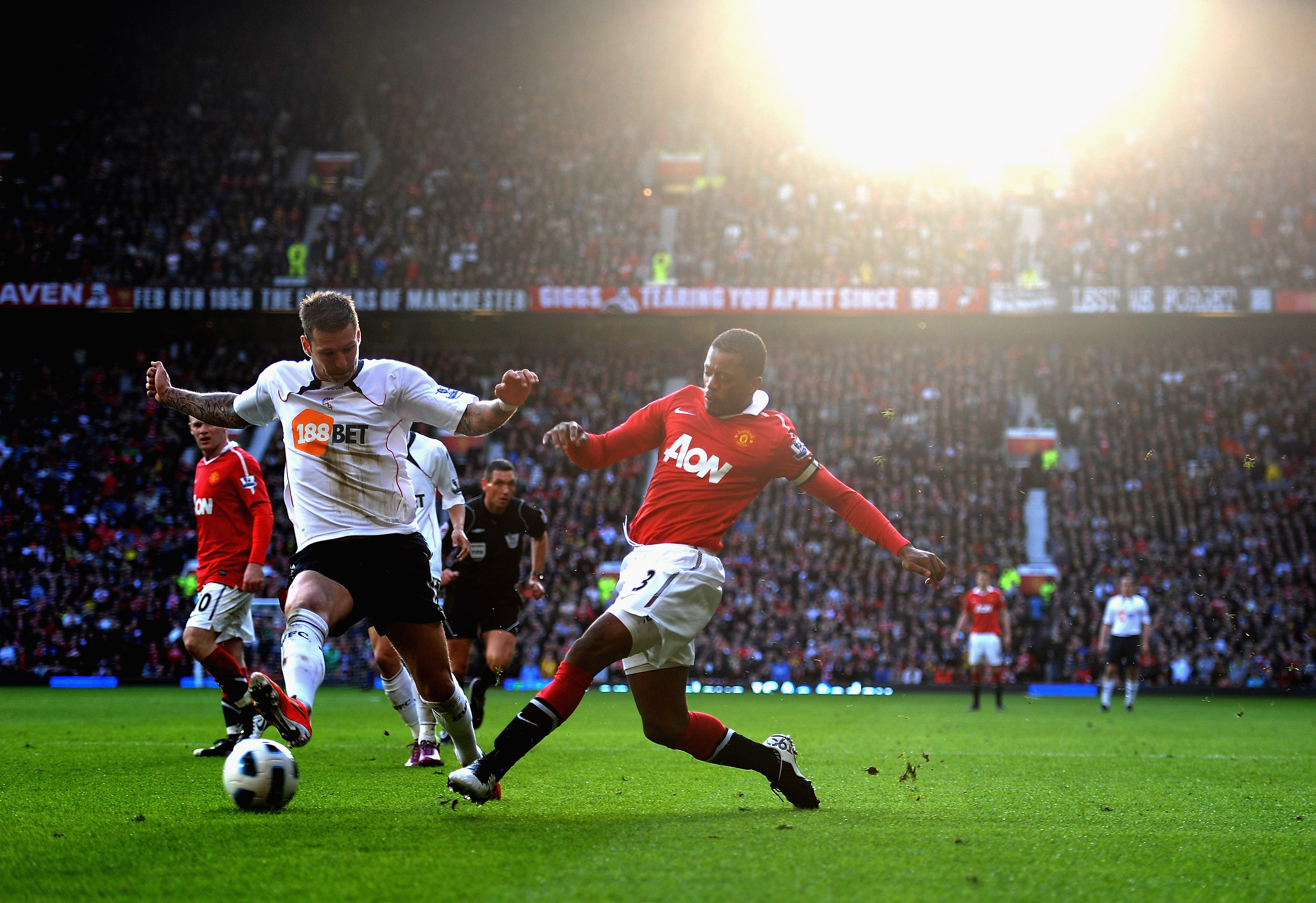 MANCHESTER, ENGLAND - MARCH 19: Patrice Evra of Manchester United battles with Gretar Rafn Steinsson of Bolton Wanderers during the Barclays Premier League match between Manchester United and Bolton Wanderers at Old Trafford on March 19, 2011 in Mancheste
