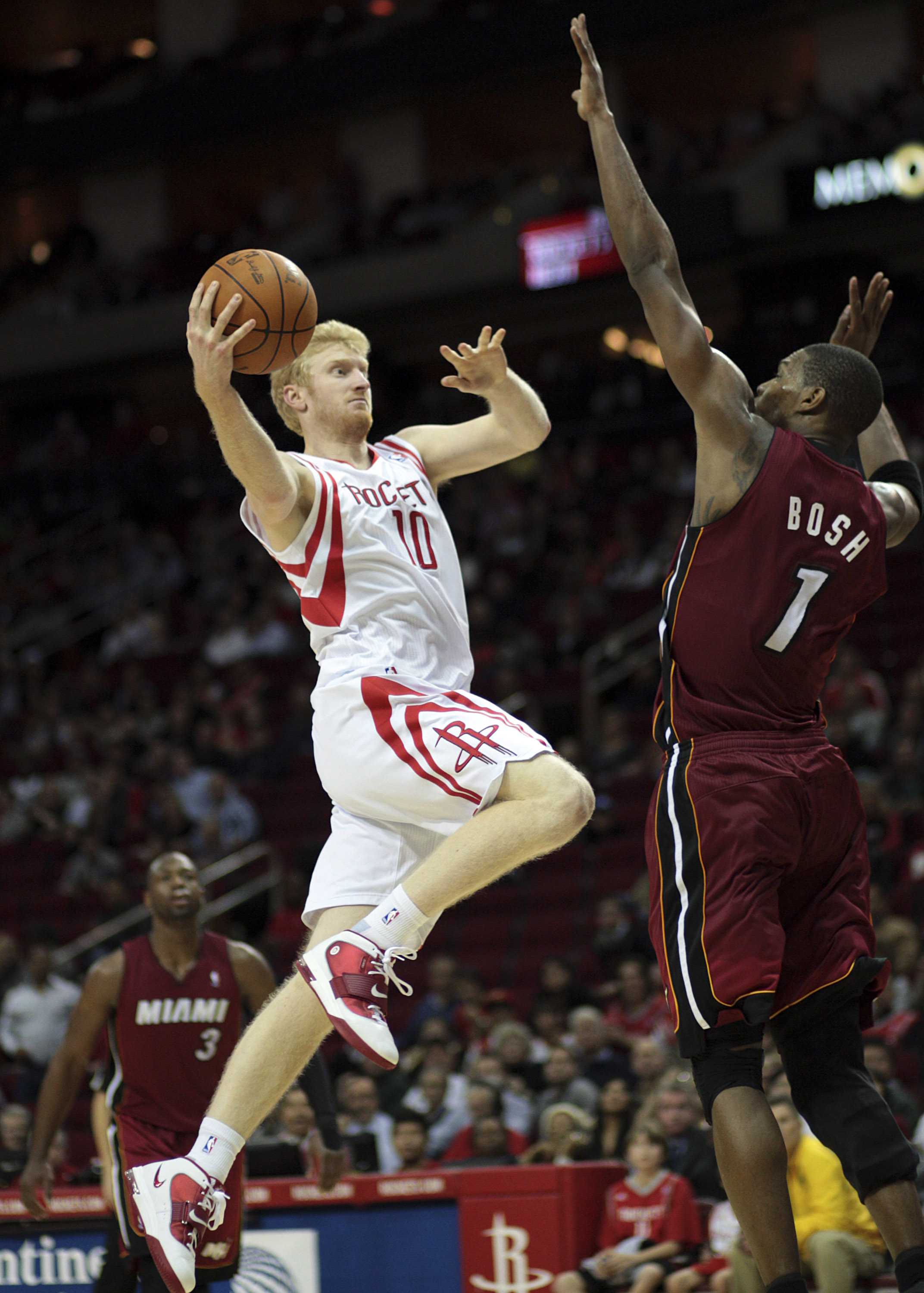 HOUSTON - DECEMBER 29: Chase Budinger #10 of the Houston Rockets drives the basket over Chris Bosh #1 of the Miami Heat in the second half at Toyota Center on December 29, 2010 in Houston, Texas. Miami won 125-119. NOTE TO USER: User expressly acknowledge
