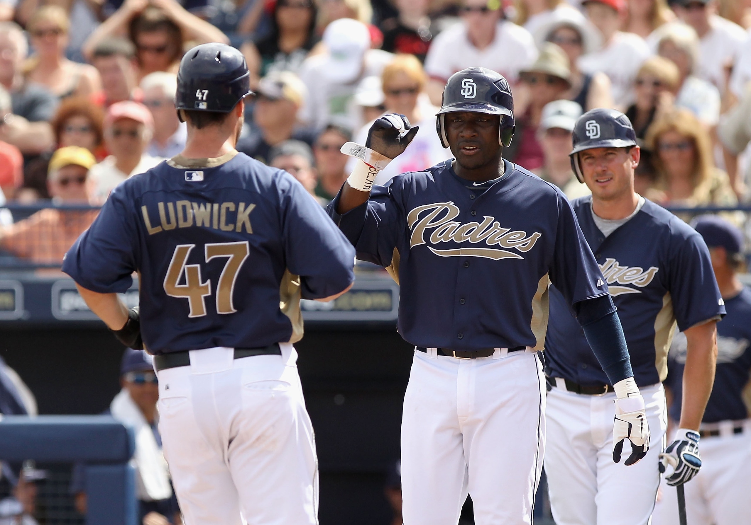 PEORIA, AZ - MARCH 15:  Ryan Ludwick #47 of the San Diego Padres is congratulated by teammates Orlando Hudson #1 and Brad Hawpe #11 after hitting a 2 run home run against the Los Angeles Angels of Anaheim during the third inning of the spring training gam