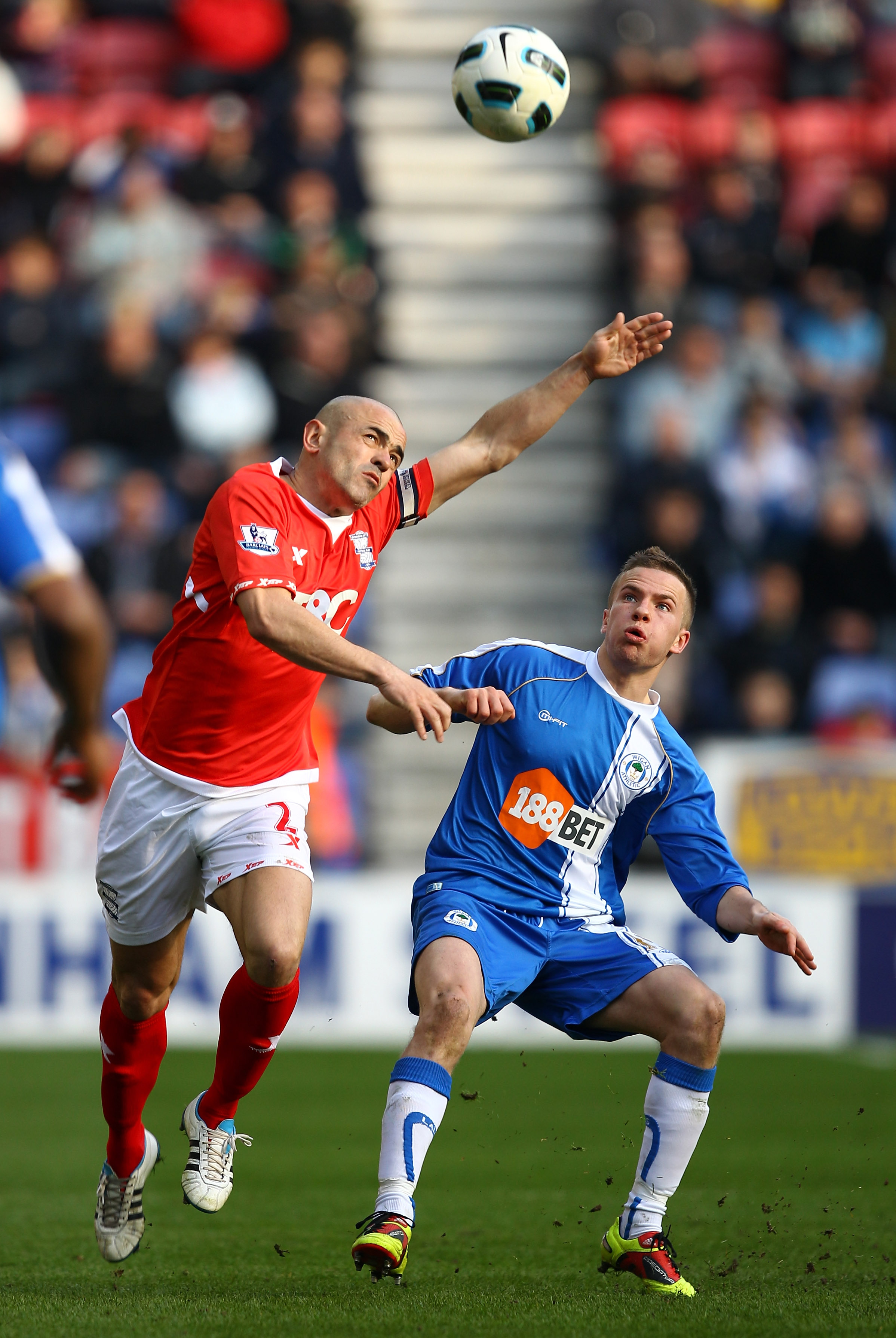 WIGAN, ENGLAND - MARCH 19:  Tom Cleverley of Wigan is tackles Stephen Carr of Birmingham during the Barclays Premier League match between Wigan Athletic and Birmingham City at the DW Stadium on March 19, 2011 in Wigan, England.  (Photo by Richard Heathcot