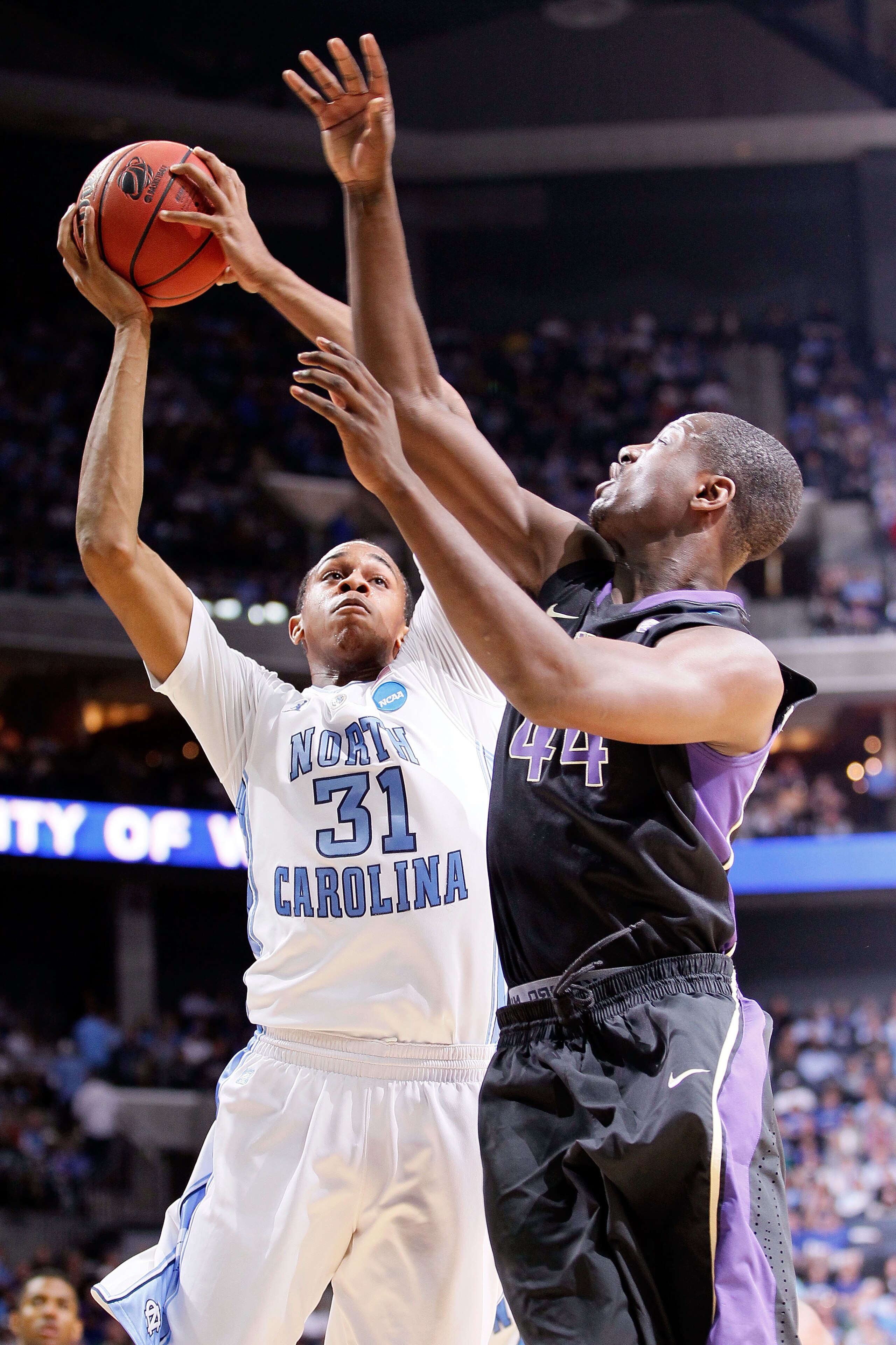 CHARLOTTE, NC - MARCH 20:  John Henson #31 of the North Carolina Tar Heels goes up for a shot over Darnell Gant #44 of the Washington Huskies in the second half during the third round of the 2011 NCAA men's basketball tournament at Time Warner Cable Arena