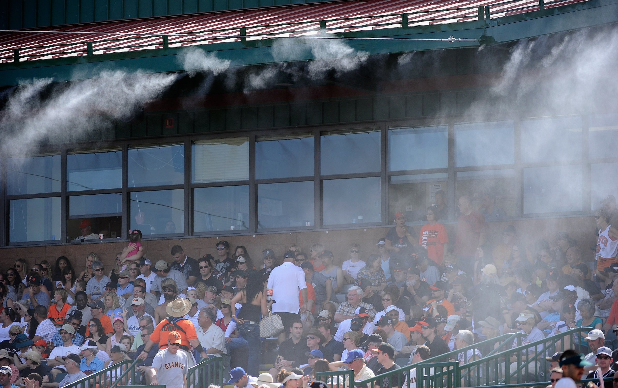 SCOTTSDALE, AZ - MARCH 18:  Mist is sprayed from the roof of the Scottsdale Stadium to keep fans cool during the spring training baseball game of the San Francisco Giants and Los Angeles Dodgers on March 18, 2011 in Scottsdale, Arizona. The temperature du