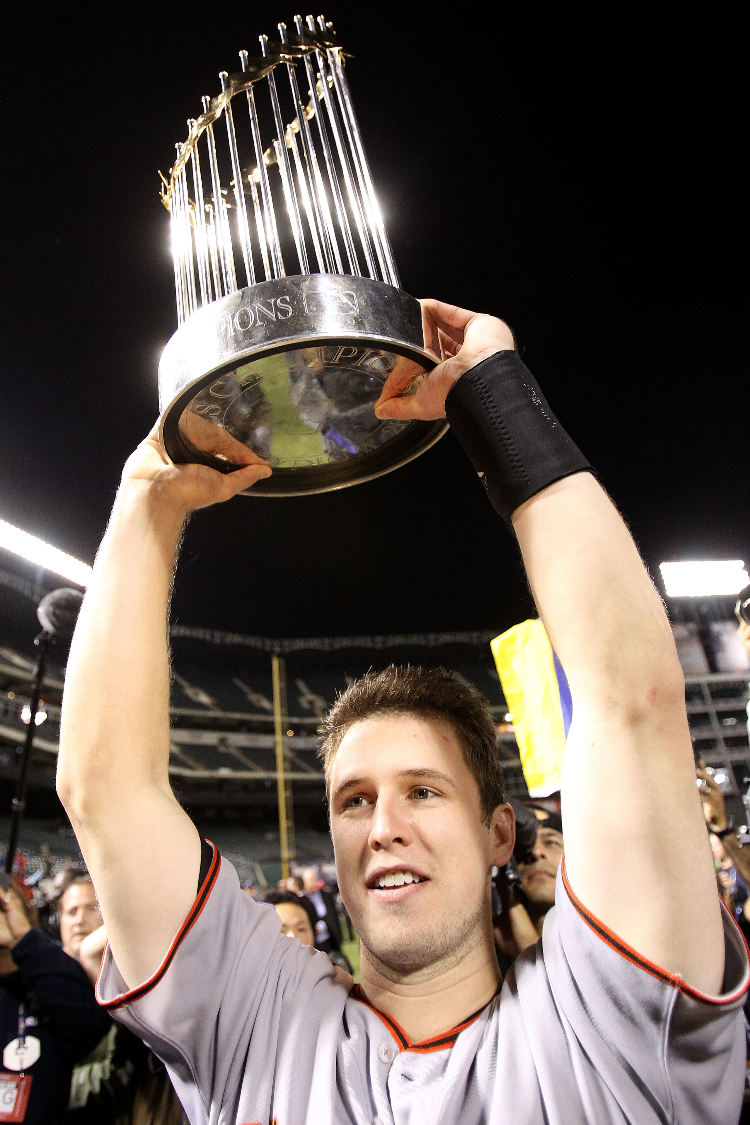 ARLINGTON, TX - NOVEMBER 01:  Buster Posey #28 of the San Francisco Giants celebrates with the World Series Championship trophy after the Giants won 3-1 the Texas Rangers in Game Five of the 2010 MLB World Series at Rangers Ballpark in Arlington on Novemb