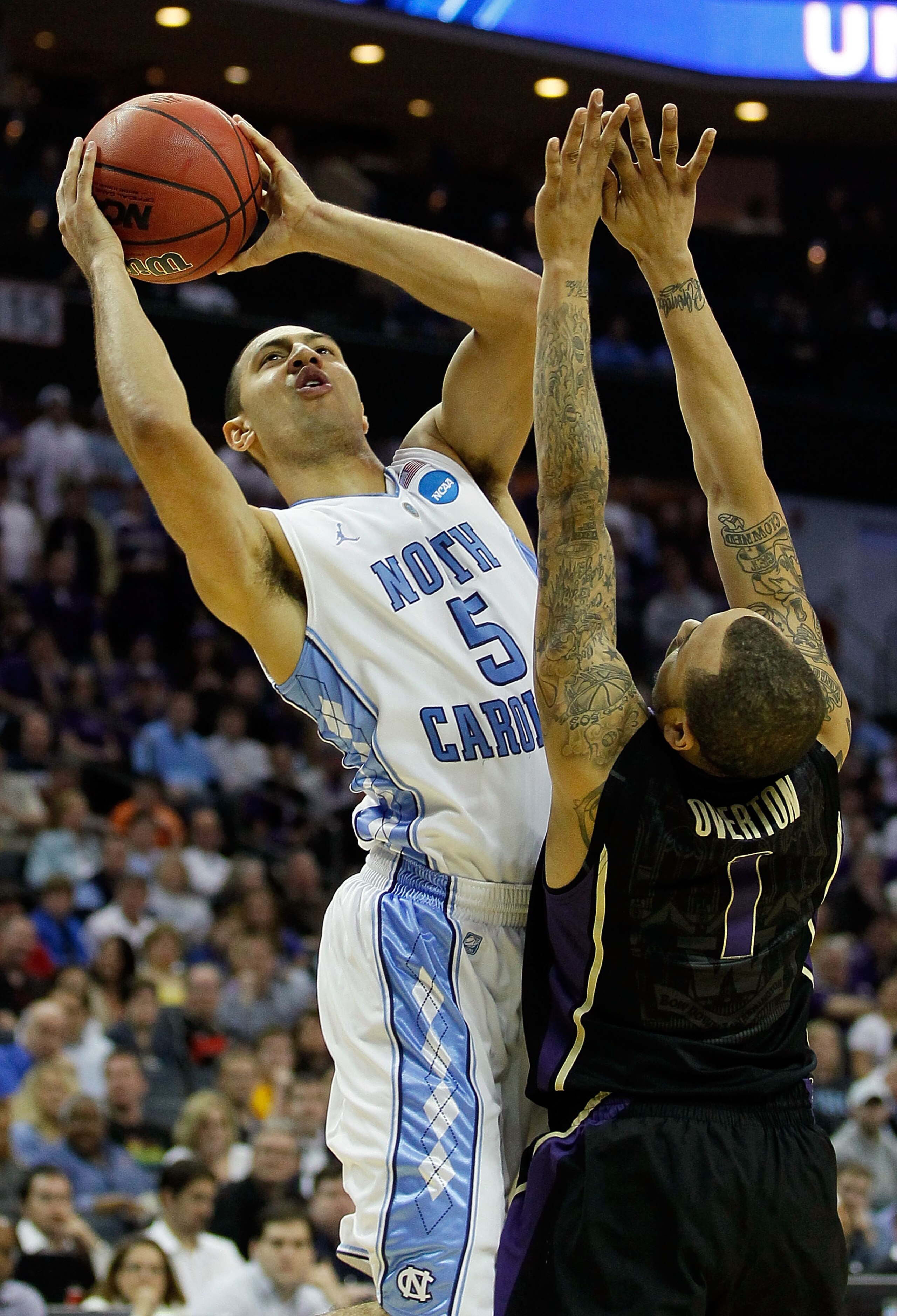 CHARLOTTE, NC - MARCH 20:  Kendall Marshall #5 of the North Carolina Tar Heels goes up for a shot over Venoy Overton #1 of the Washington Huskies in the second half during the third round of the 2011 NCAA men's basketball tournament at Time Warner Cable A