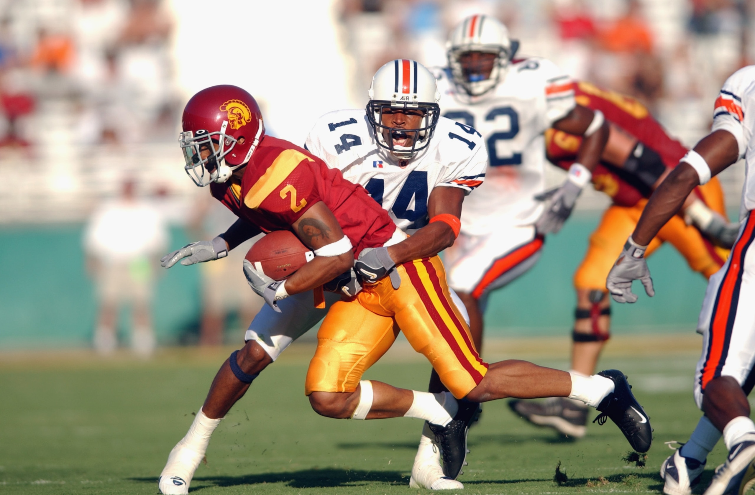 LOS ANGELES - SEPTEMBER 2:  Wide receiver Kareem Kelly #2 of the USC Trojans is tackled by defensiveback Carlos Rogers #14 of the Auburn Tigers at the Los Angeles Coliseum on September 2, 2002 in Los Angeles, California. USC defeated Auburn 24-17.  (Photo
