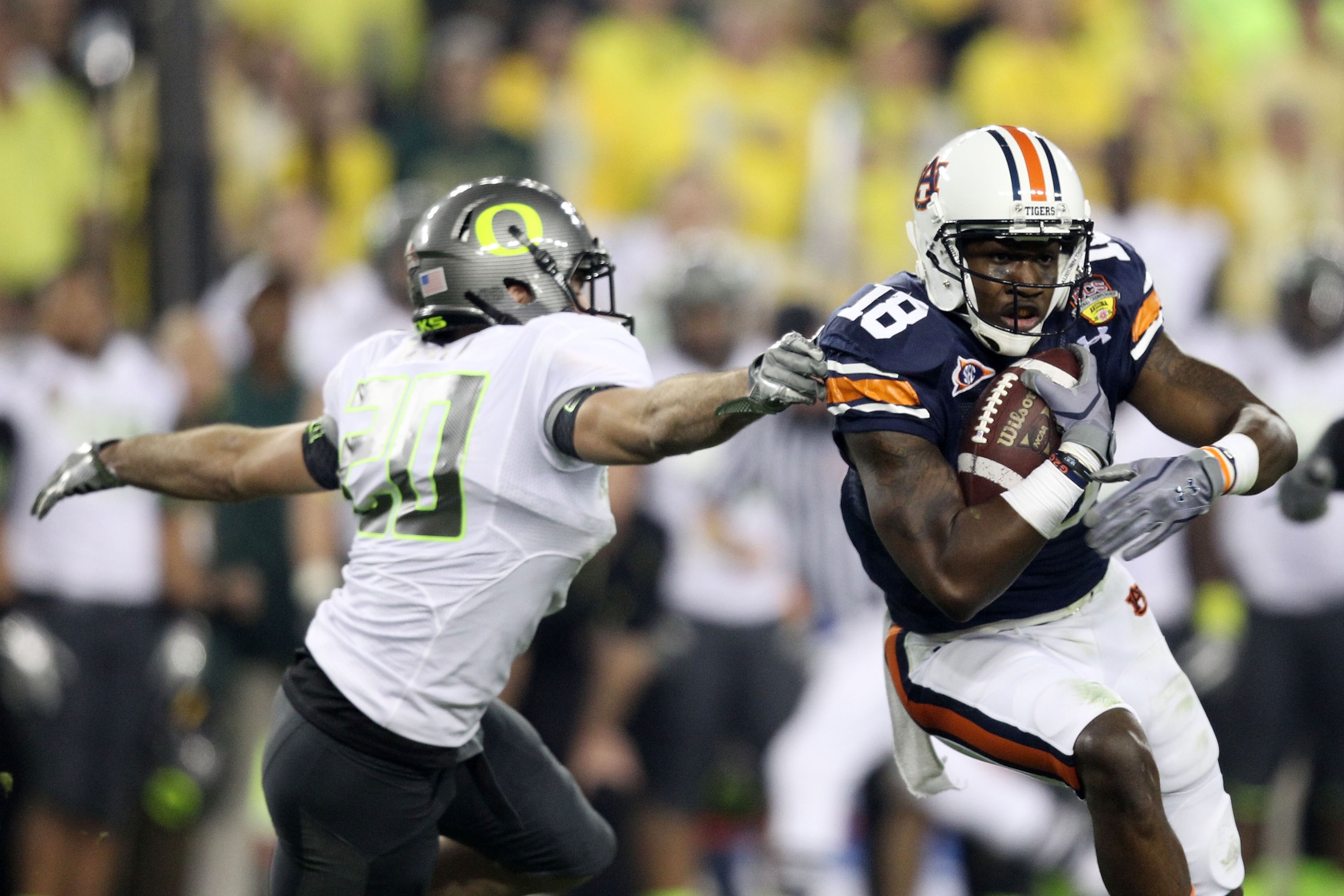GLENDALE, AZ - JANUARY 10:  Kodi Burns #18 of the Auburn Tigers tries to avoid the tackle of John Boyett #20 of the Oregon Ducks during the Tostitos BCS National Championship Game at University of Phoenix Stadium on January 10, 2011 in Glendale, Arizona.