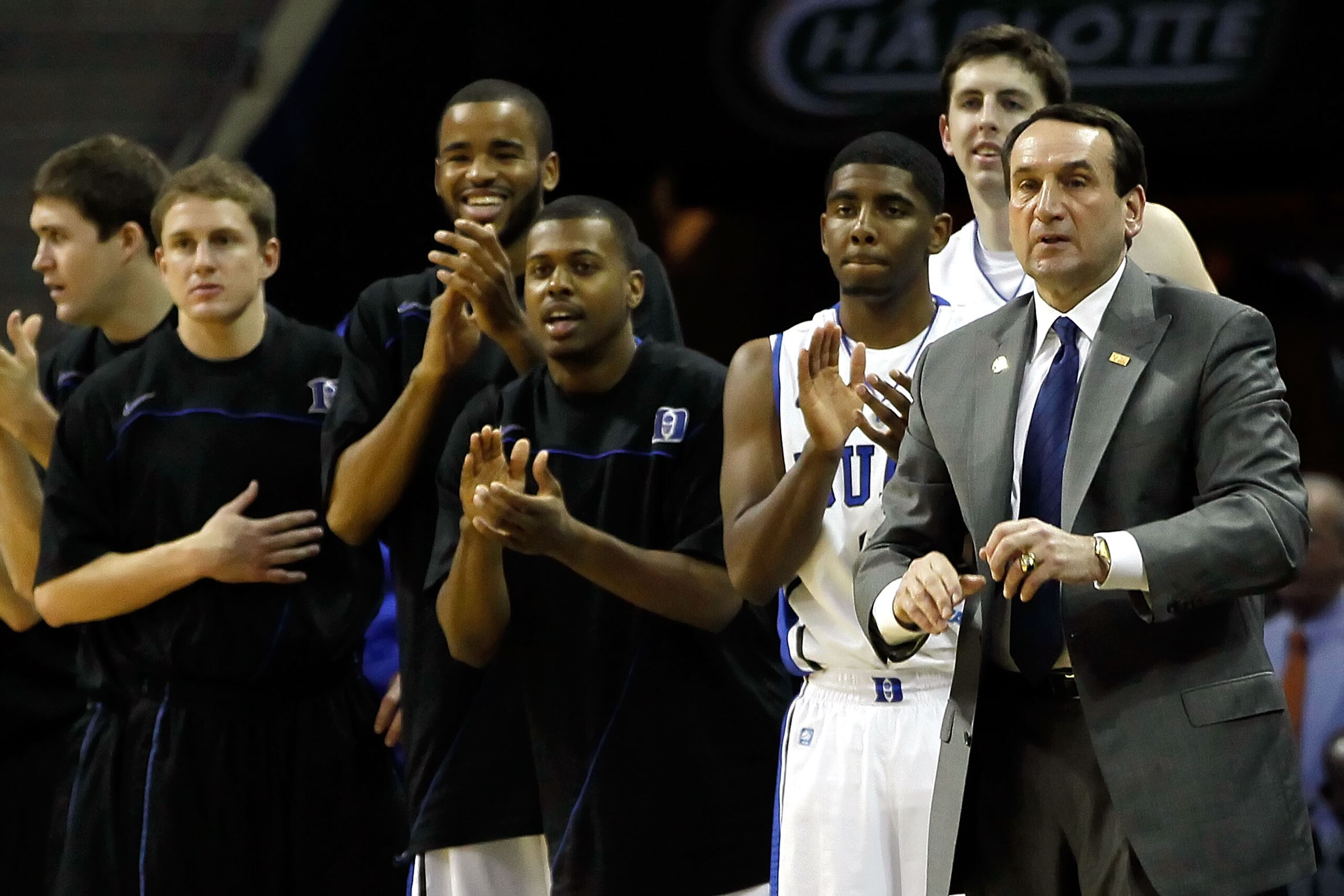 CHARLOTTE, NC - MARCH 18:  (R) Head coach Mike Krzyzewski of the Duke Blue Devils and the rest of the Blue Devils bench cheer after a basket by Andre Dawkins #20 while taking on the Hampton Pirates during the second round of the 2011 NCAA men's basketball