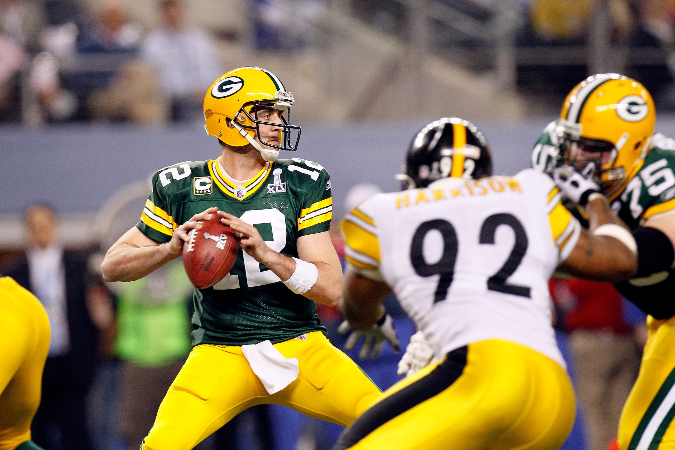 ARLINGTON, TX - FEBRUARY 06:  Aaron Rodgers #12 of the Green Bay Packers looks to pass against James Harrison #92 of the Pittsburgh Steelers during Super Bowl XLV at Cowboys Stadium on February 6, 2011 in Arlington, Texas. The Packers won 31-25.  (Photo b