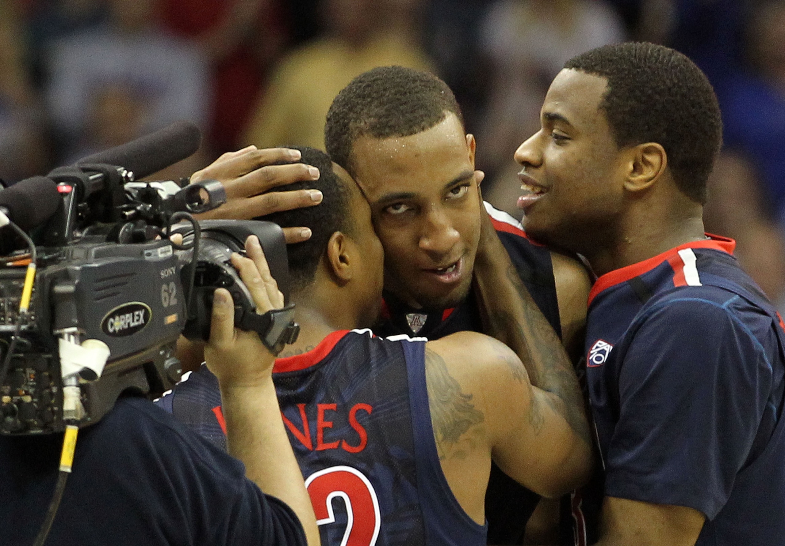 TULSA, OK - MARCH 20:  Derrick Williams #23 of the Arizona Wildcats celebrates with teammates Kevin Parrom #3 and Lamont Jones #12 after defeating the Texas Longhorns 70-69 in the third round of the 2011 NCAA men's basketball tournament at BOK Center on M