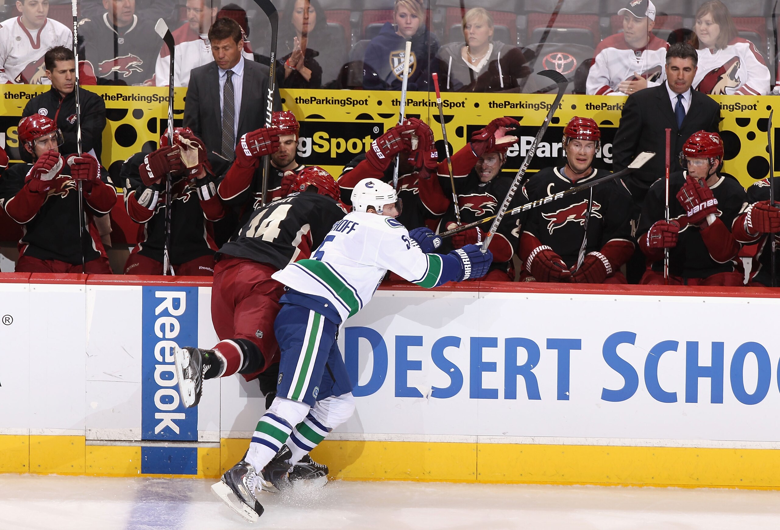 GLENDALE, AZ - MARCH 08:  Christian Ehrhoff #4 of the Vancouver Canucks lays a body check onto Taylor Pyatt #14 of the Phoenix Coyotes during the first period of the NHL game at Jobing.com Arena on March 8, 2011 in Glendale, Arizona.  (Photo by Christian