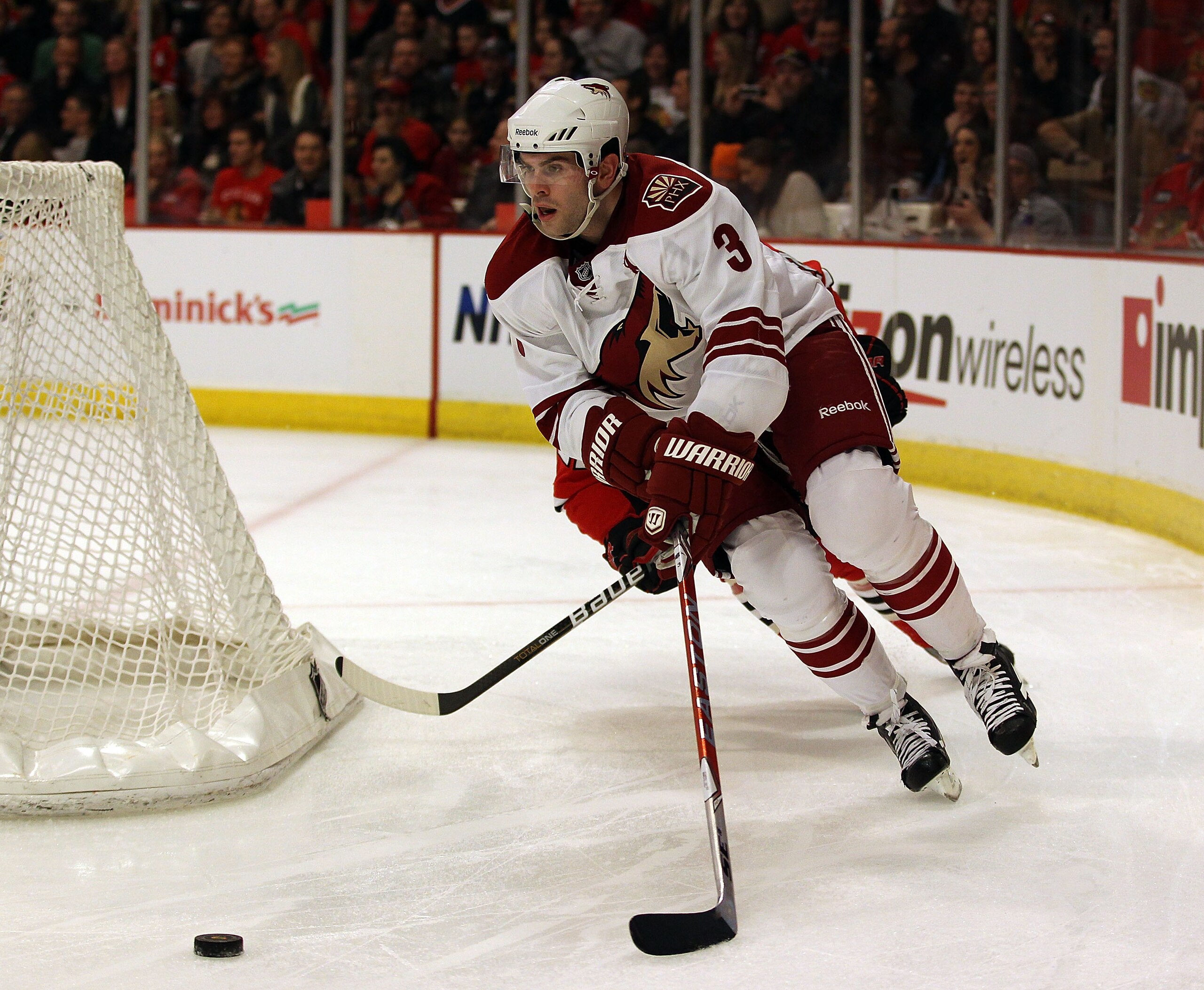 CHICAGO, IL - FEBRUARY 27: Keith Yandle #3 of the Phoenix Coyotes chases down the puck behind the Coyote net in front of Troy Brouwer #22 of the Chicago Blackhawks at the United Center on February 27, 2011 in Chicago, Illinois. The Blackhawks defeated the