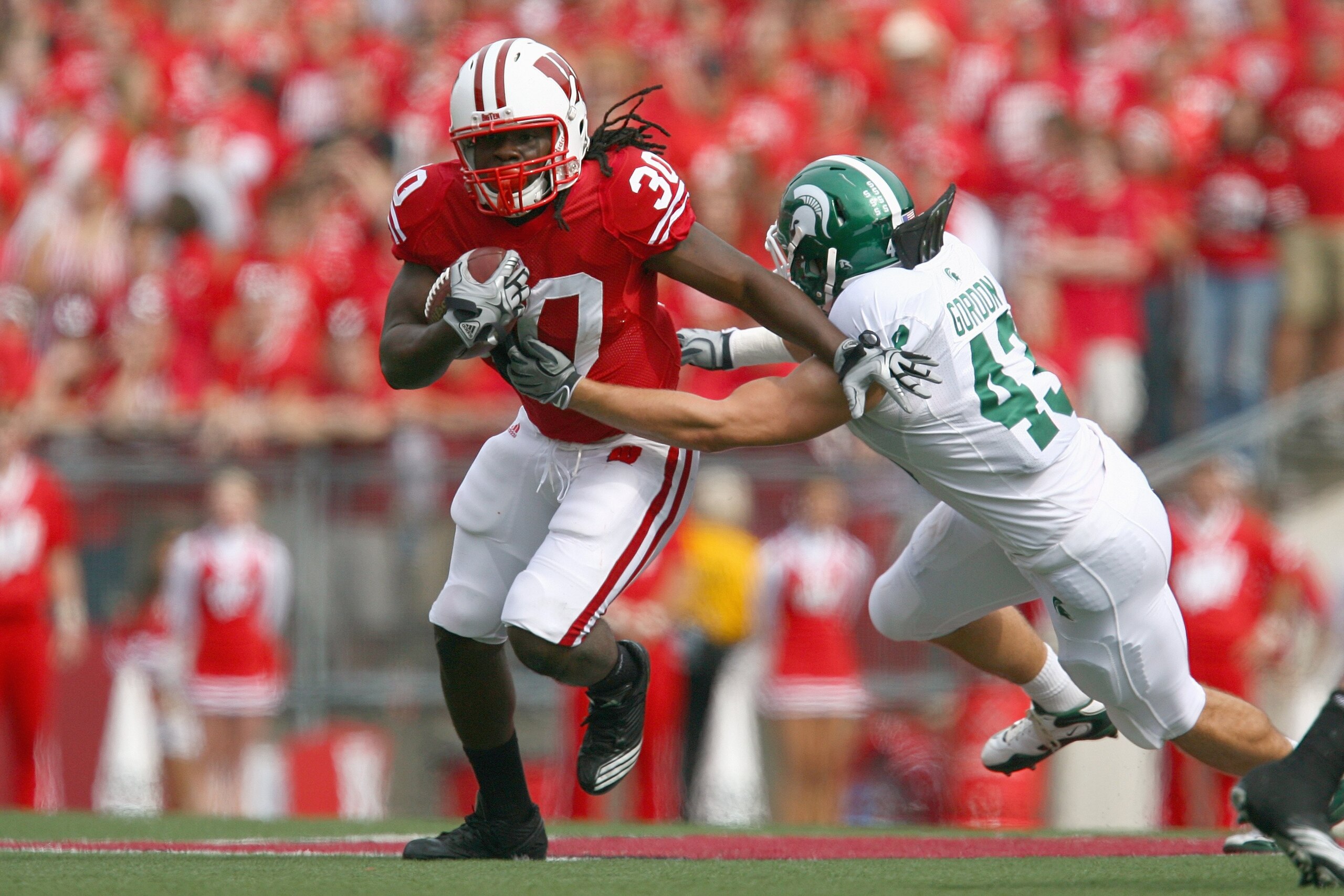 MADISON, WI - SEPTEMBER 26: Zach Brown #30 of the Wisconsin Badgers carries the ball against Eric Gordon #43 of the Michigan State Spartans on September 26, 2009 at Camp Randall Stadium in Madison, Wisconsin. (Photo by Jonathan Daniel/Getty Images)