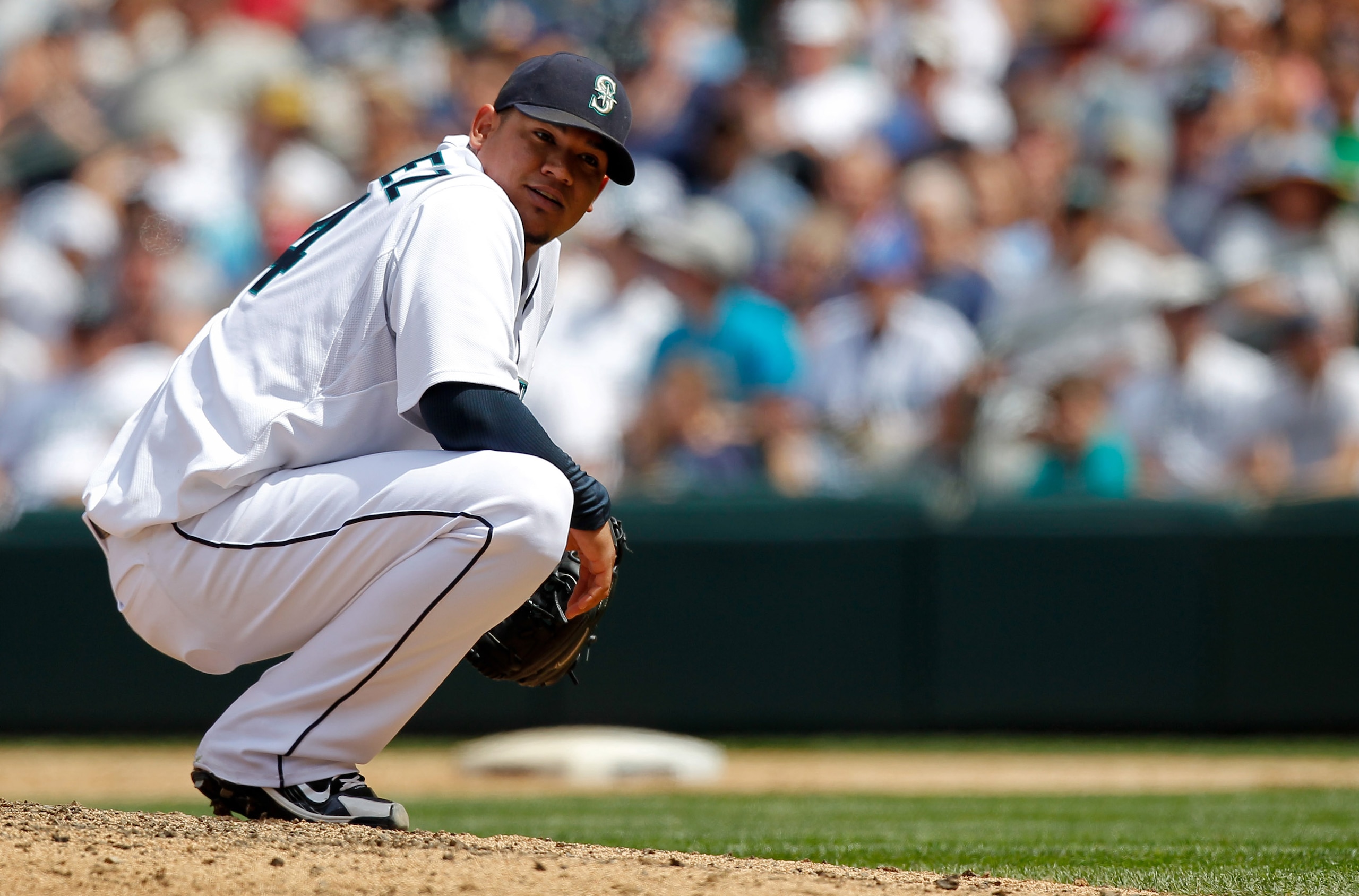 SEATTLE - JUNE 24: Starting pitcher Felix Hernandez #34 of the Seattle Mariners looks back at third baseman Jose Lopez after having to duck his throw to first base on a ground out by Ryan Theriot of the Chicago Cubs at Safeco Field on June 24, 2010 in Sea