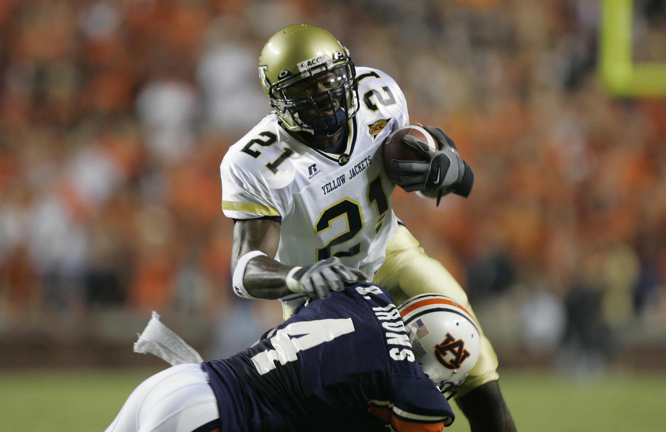 AUBURN, AL - SEPTEMBER 3:  Wide receiver Calvin Johnson #21 of the Georgia Tech Yellow Jackets runs the ball as Defensive back David Irons #4 of the Auburn Tigers goes for the tackle during the game on September 3, 2005 at Jordan-Hare Stadium in Auburn, A