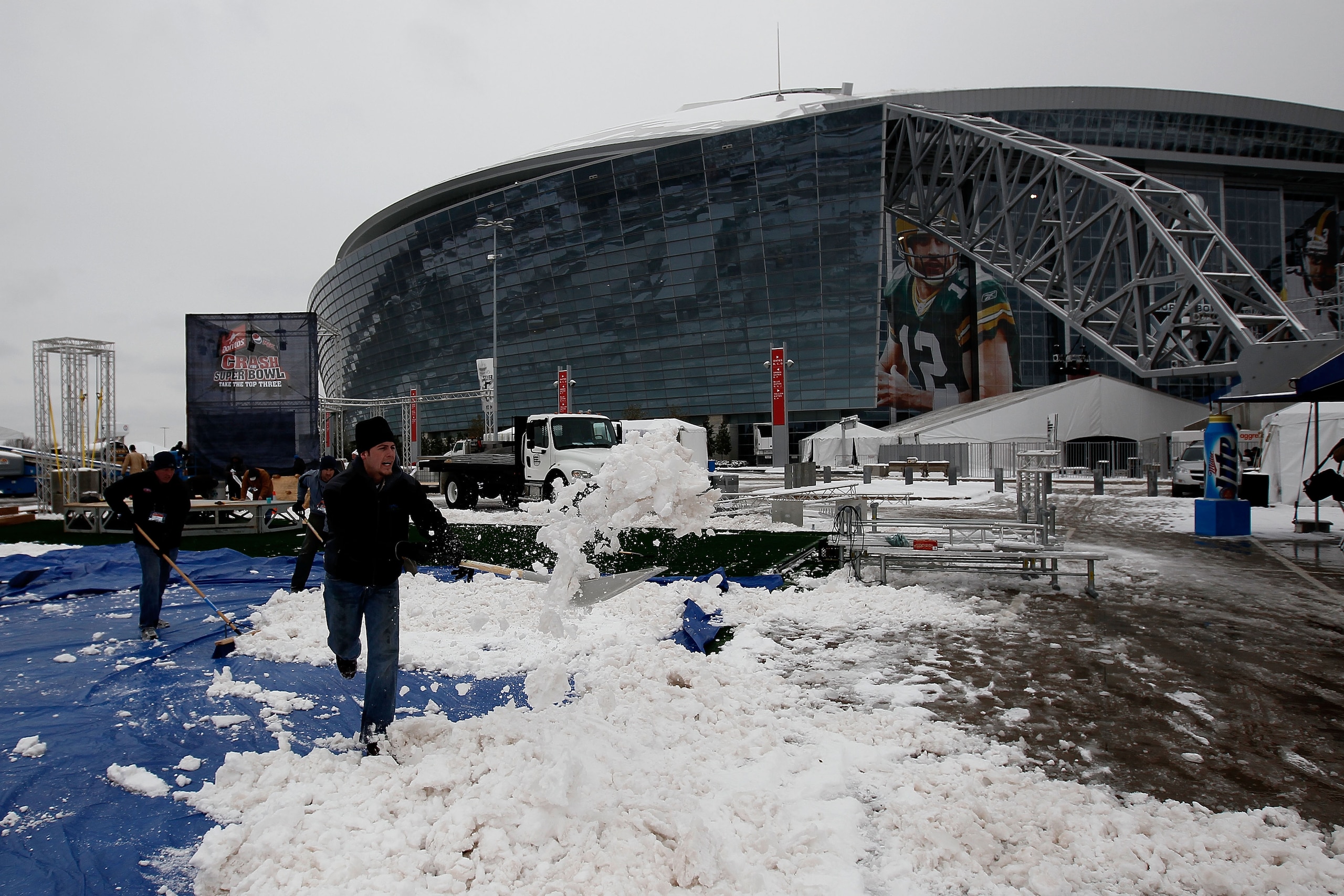 ARLINGTON, TX - FEBRUARY 04:  Workers clear snow outside the perimeter of Cowboys Stadium after a snowstorm hit the area February 4, 2011 in Dallas, Texas. More than four inches of snow fell overnight in the North Texas area. The Green Bay Packers will pl