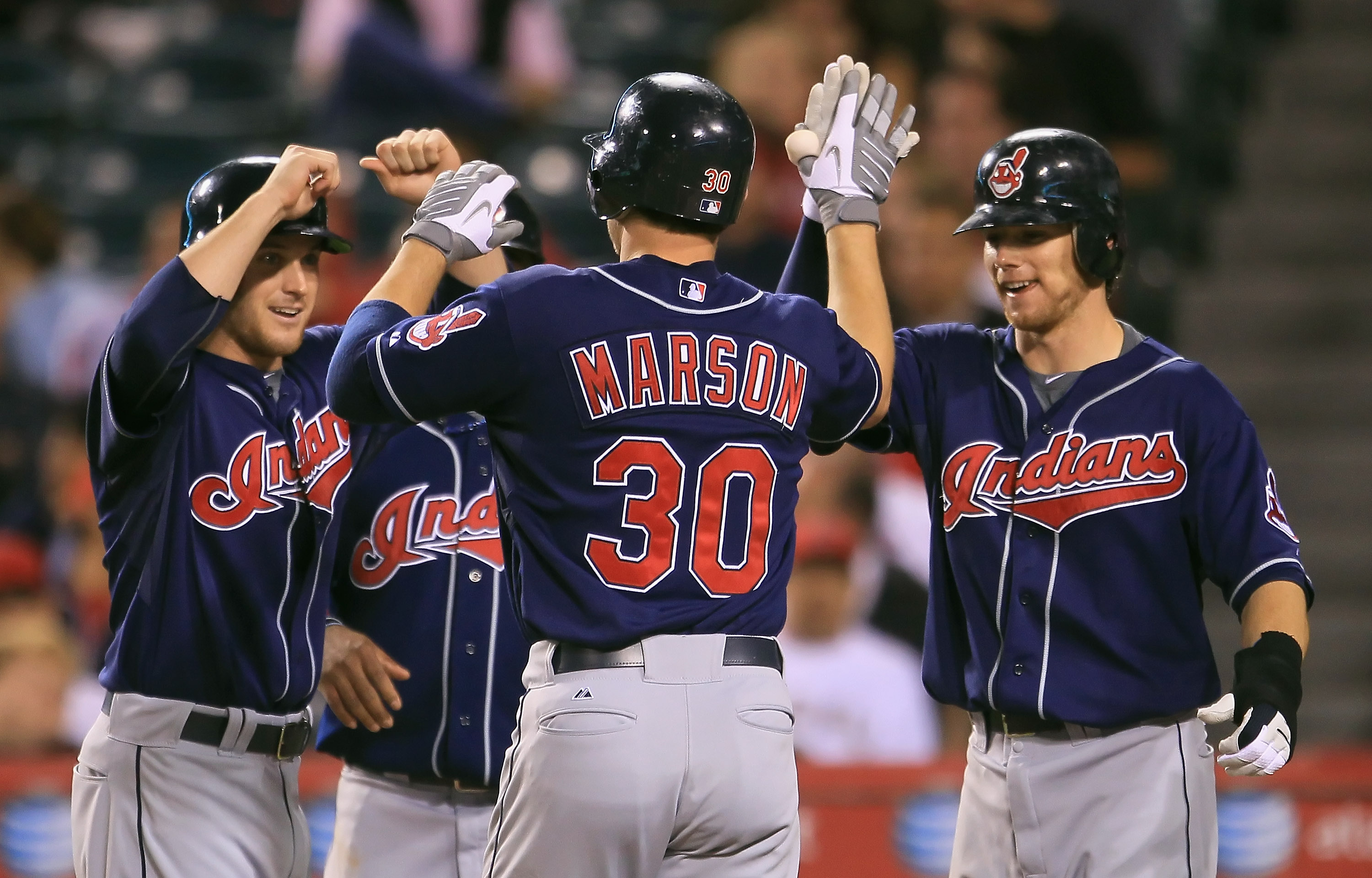 ANAHEIM, CA - SEPTEMBER 07:  (L-R) Trevor Crowe #4, Lou Marson #30 and Jason Donald #16 of the Cleveland Indians celebrate Marson's grand slam home run in the sixth inning against the Los Angeles Angels of Anaheim at Angel Stadium on September 7, 2010 in