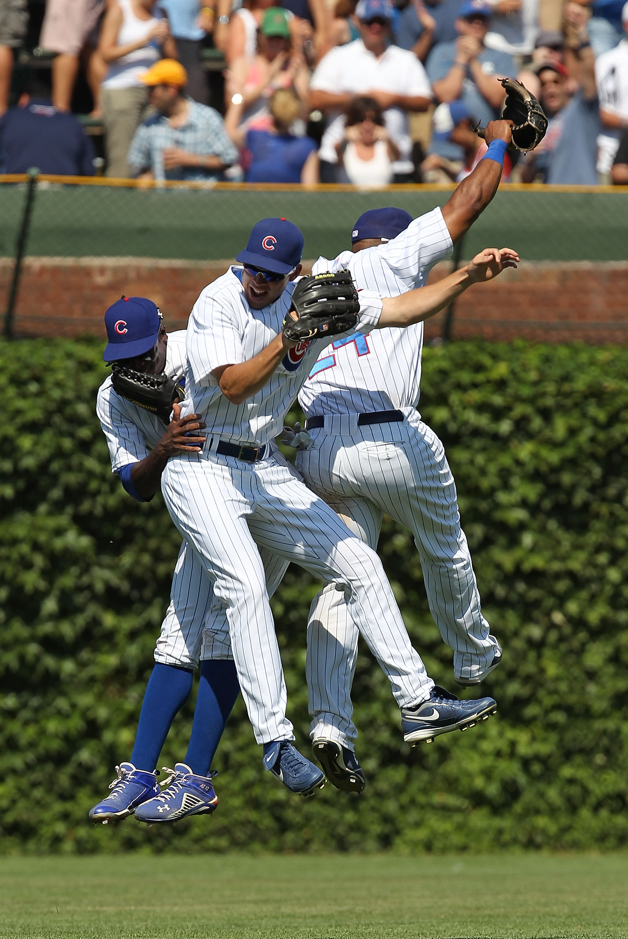 CHICAGO - JULY 16: (L-R) Alfonso Soriano #12, Tyler Colvin #21 and Marlon Byrd #24 of the Chicago Cubs celebrate a win over the Philadelphia Phillies at Wrigley Field on July 16, 2010 in Chicago, Illinois. The Cubs defeated the Phillies 4-3. (Photo by Jon