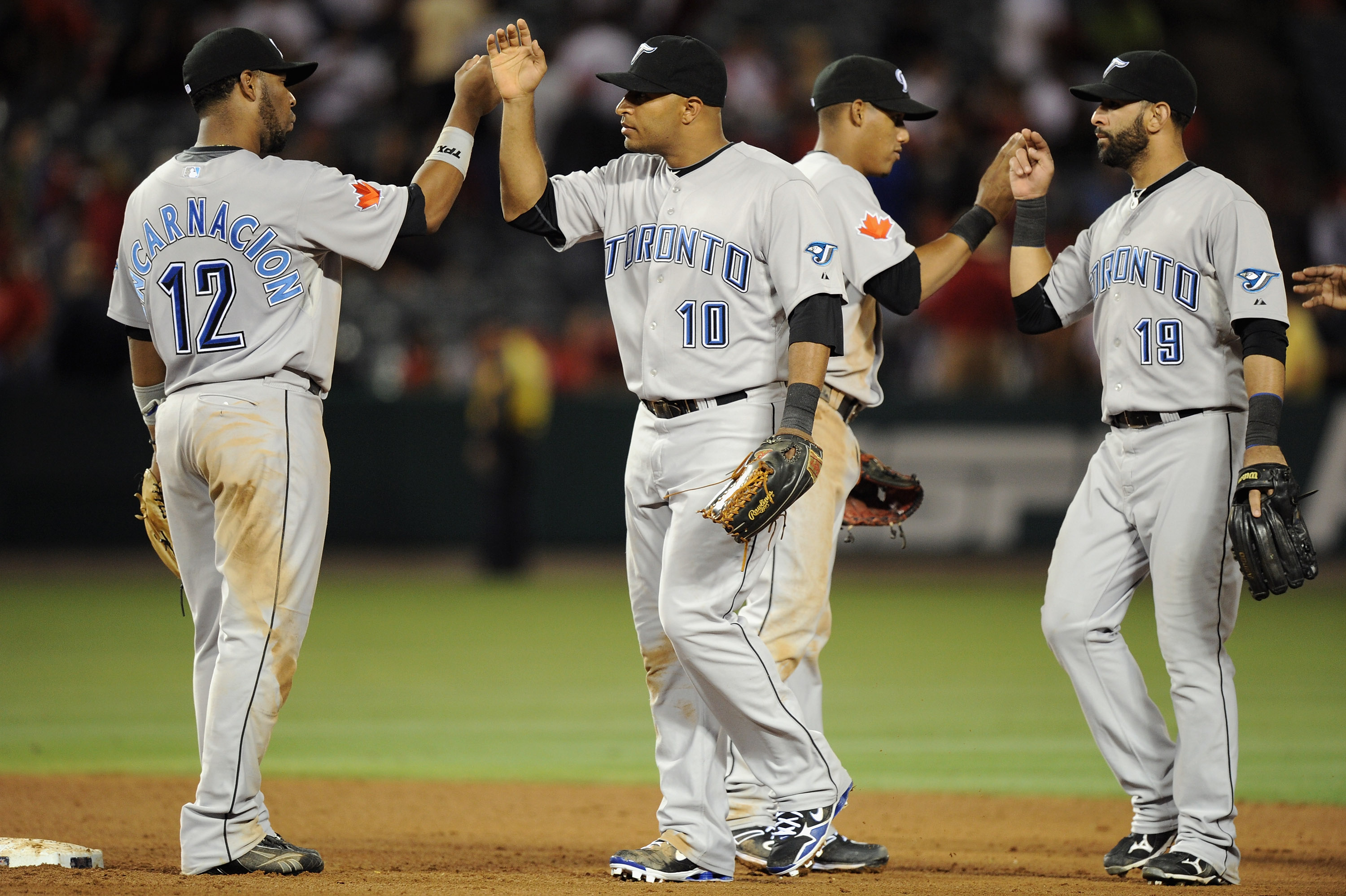 ANAHEIM, CA - AUGUST 13:  Vernon Wells #10, Edwin Encarnacion #12 Jose Bautista and Yunel Escobar #5 of the Toronto Blue Jays celebrate a 3-0 win over the Los Angeles Angels at Angel Stadium on August 13, 2010 in Anaheim, California.  (Photo by Harry How/