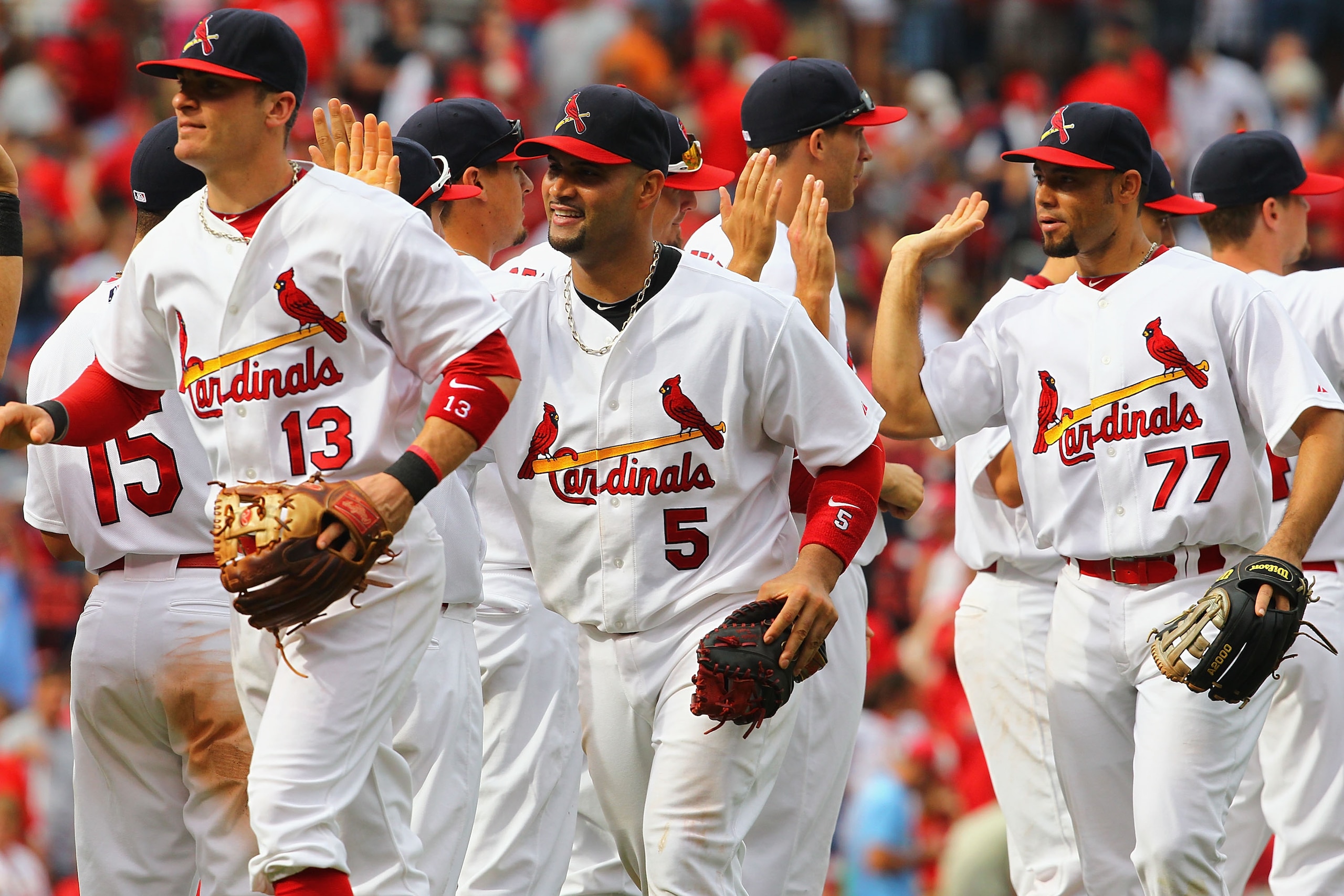 ST. LOUIS - SEPTEMBER 19: Brendan Ryan #13, Albert Pujols #5 and Pedro Feliz #77 all of the St. Louis Cardinals celebrate a victory over the San Diego Padres at Busch Stadium on September 19, 2010 in St. Louis, Missouri.  The Cardinals beat the Padres 4-1