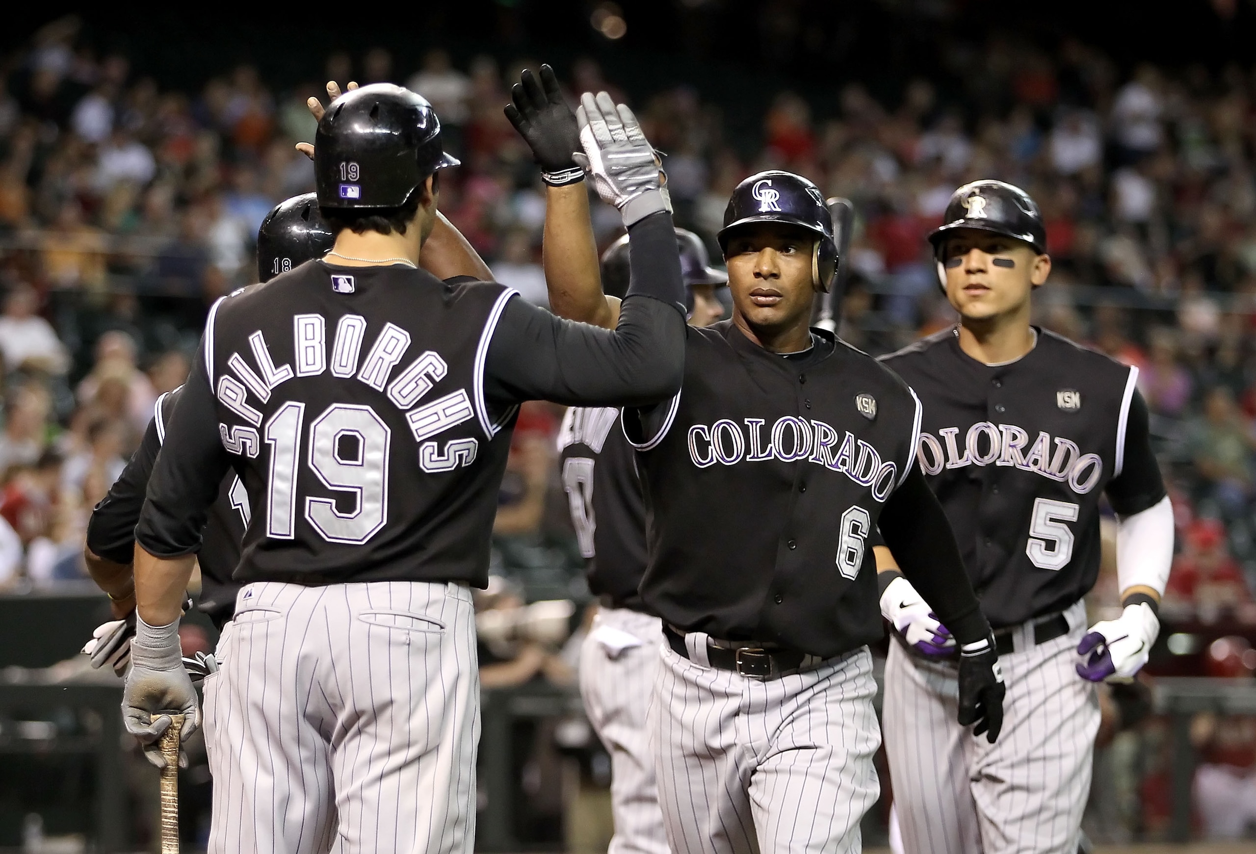 PHOENIX - SEPTEMBER 22:  Melvin Mora #6 of the Colorado Rockies celebrates with teammates Ryan Spilborghs #19, Jonathan Herrera #18 and Carlos Gonzalez #5 after Mora hit a three-run homerun against the Arizona Diamondbacks during the first inning of the M