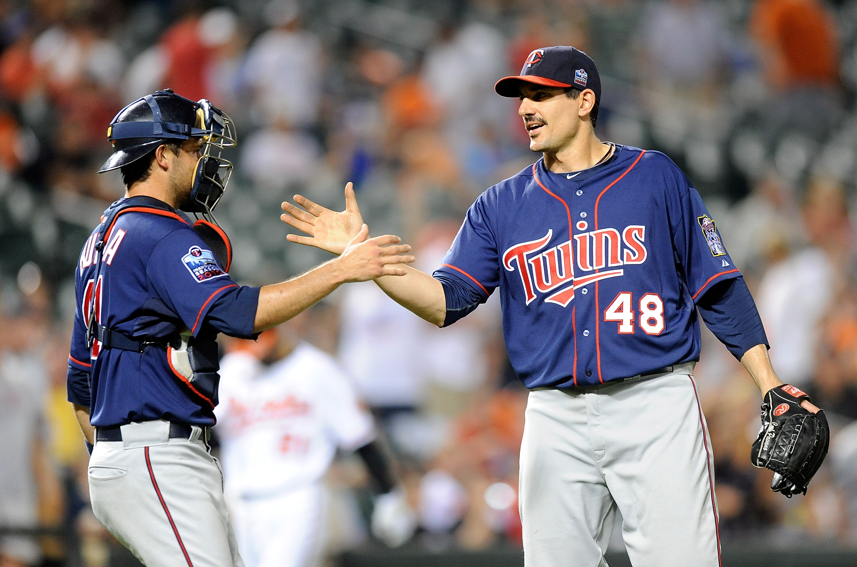 BALTIMORE - JULY 22:  Carl Pavano #48 of the Minnesota Twins celebrates with Drew Butera #41 after pitching a complete game shutout against the Baltimore Orioles at Camden Yards on July 22, 2010 in Baltimore, Maryland.  The Twins won the game 5-0. (Photo