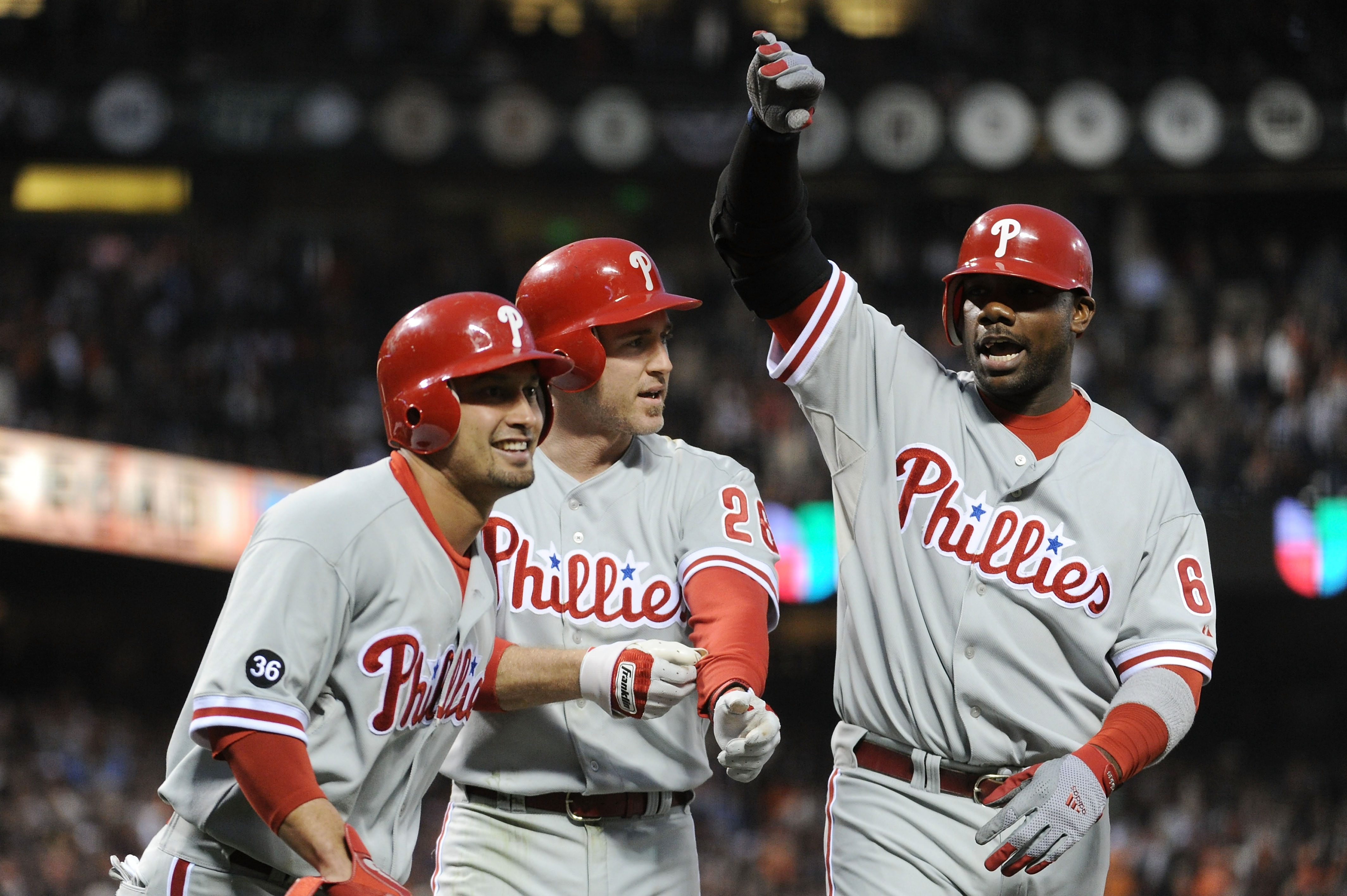SAN FRANCISCO - OCTOBER 20:  (L-R) Shane Victorino #8, Chase Utley #26, and Ryan Howard #6 of the Philadelphia Phillies celebrate after Victorino and Utley scored on a double by Placido Polanco #27 against the San Francisco Giants in Game Four of the NLCS