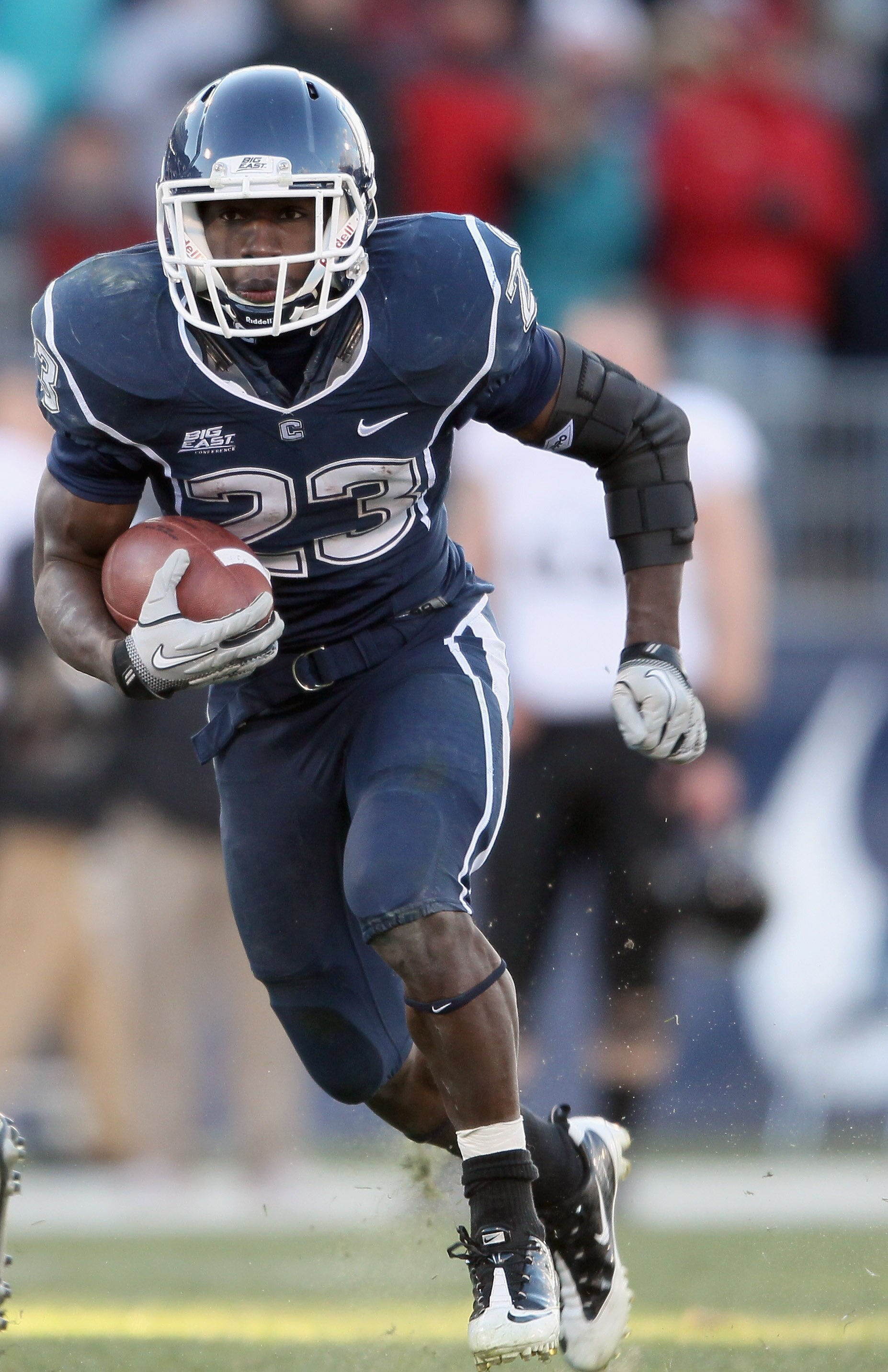 EAST HARTFORD, CT - NOVEMBER 27:  Jordan Todman #23 of the Connecticut Huskies carries the ball around the Cincinnati Bearcats defense on November 27, 2010 at Rentschler Field in East Hartford, Connecticut. The Huskies defeated the Bearcats 38-17.  (Photo