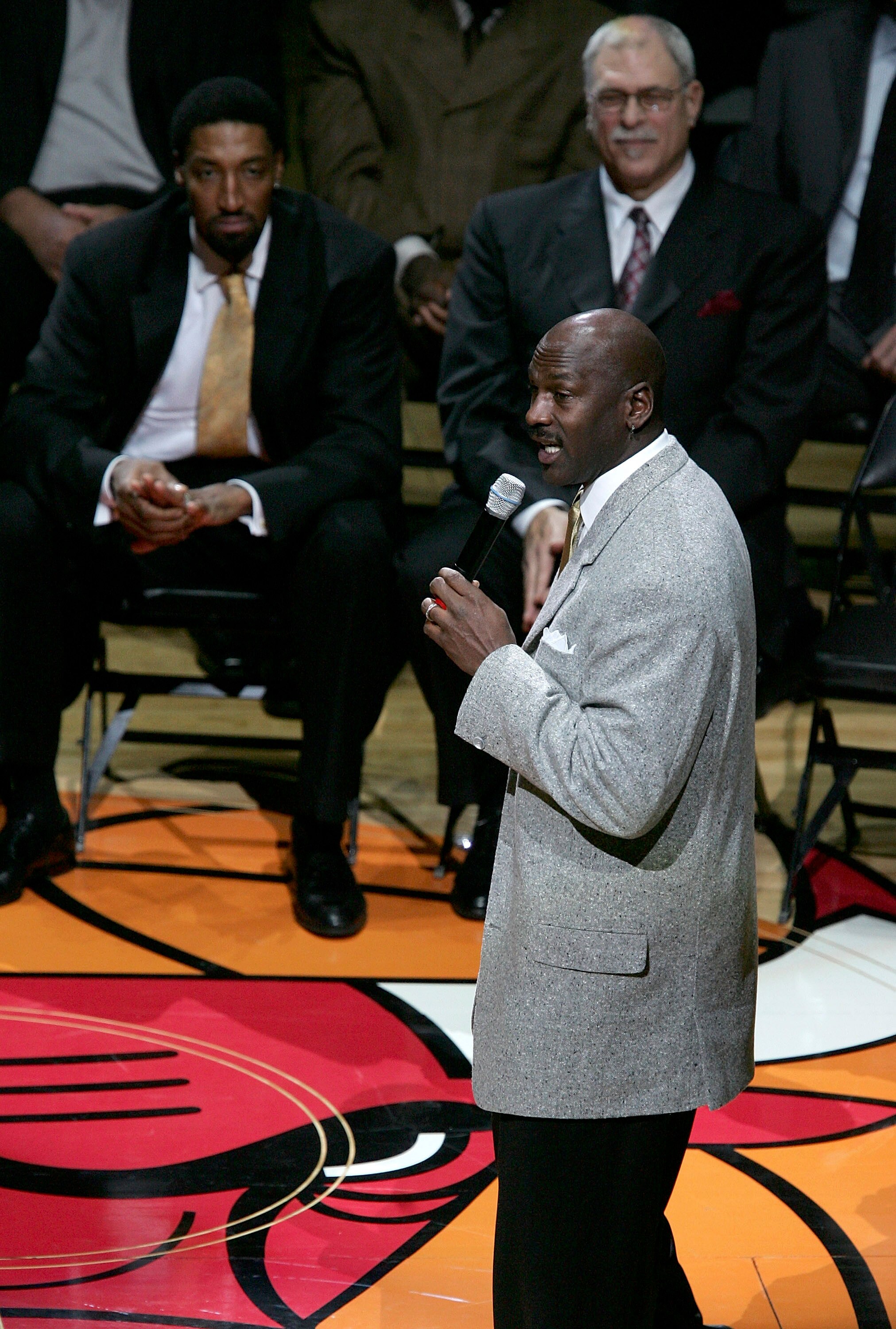CHICAGO - DECEMBER 9:  Michael Jordan, formerly of the Chicago Bulls, speaks to the crowd as former teammate Scottie Pippen (L) and former coach Phil Jackson listen during a ceremony retiring Pippen's #33 at halftime of a game between the Bulls and the Lo
