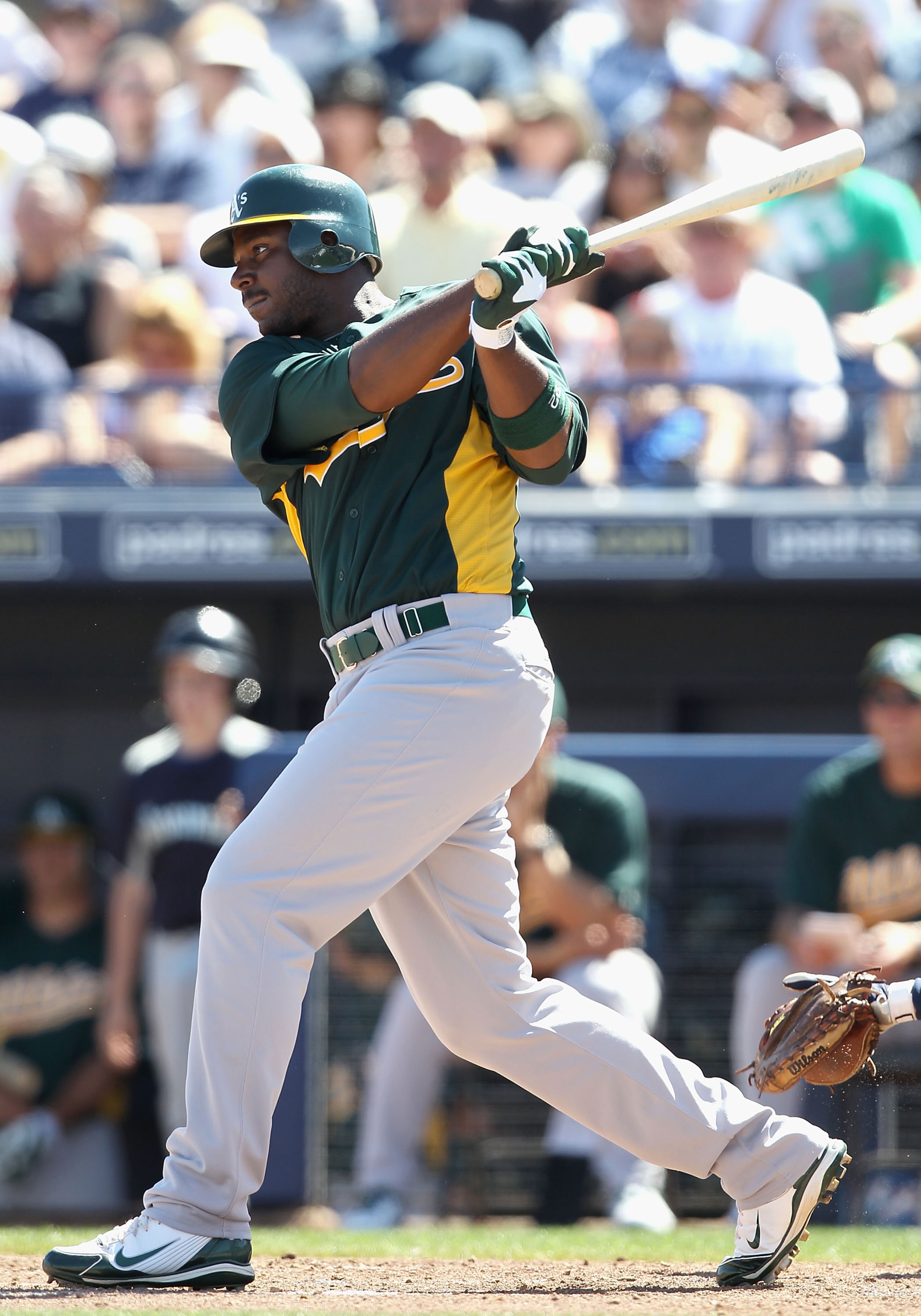 PEORIA, AZ - MARCH 12:  Chris Carter #22 of the Oakland Athletics hits a RBI single against the Seattle Mariners during the second inning of the spring training game at Peoria Stadium on March 12, 2011 in Peoria, Arizona.  (Photo by Christian Petersen/Get