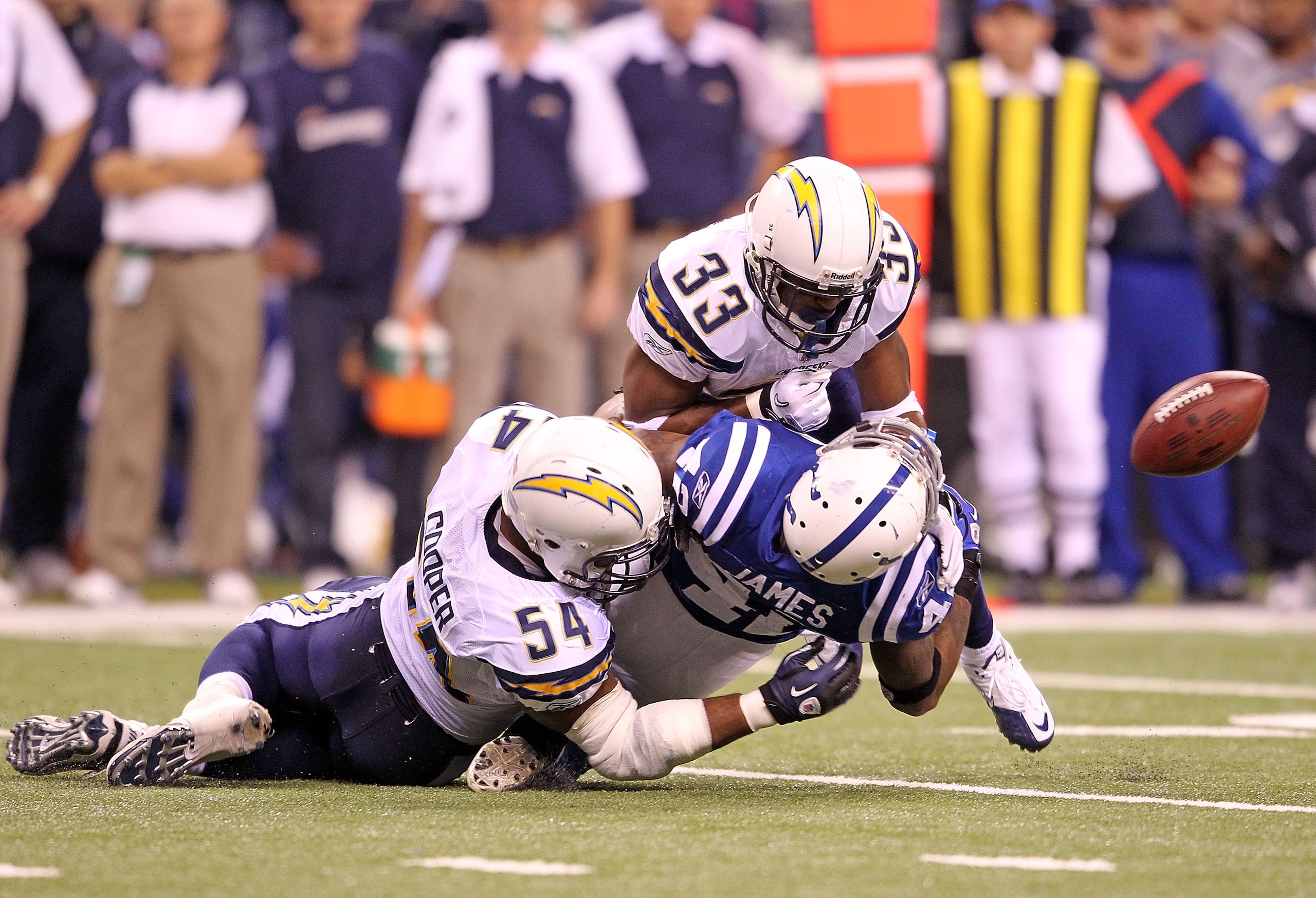 INDIANAPOLIS - NOVEMBER 28:  Javarris James #42 of the Indianapolis Colts fumbles the ball while being  tackled by Stephen Cooper #54 and Dante Hughes #33 of the San Diego Chargers during the NFL game at Lucas Oil Stadium on November 28, 2010 in Indianapo