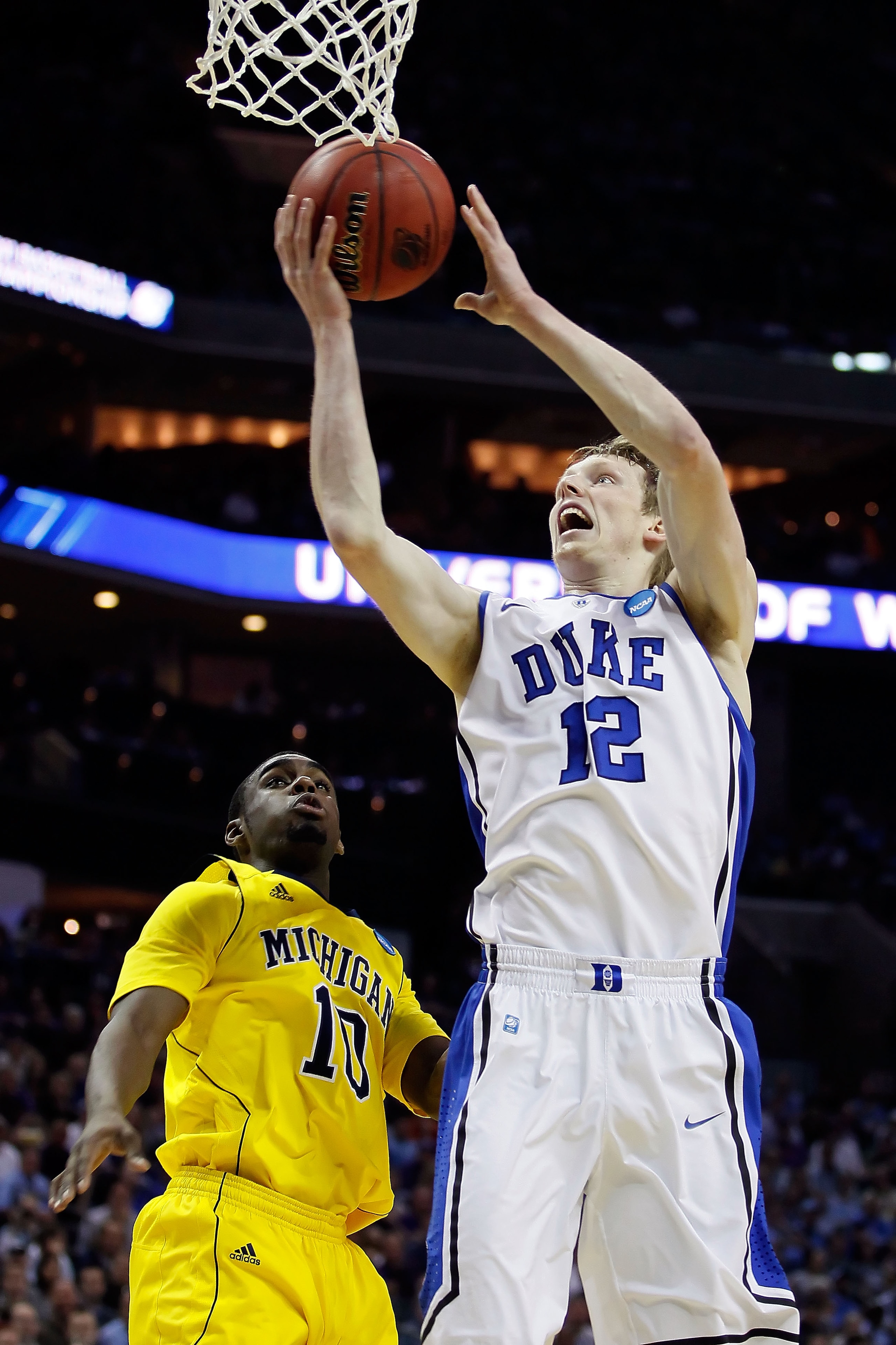 CHARLOTTE, NC - MARCH 20:  Kyle Singler #12 of the Duke Blue Devils goes up for a shot against Tim Hardaway Jr. #10 of the Michigan Wolverines in the first half during the third round of the 2011 NCAA men's basketball tournament at Time Warner Cable Arena