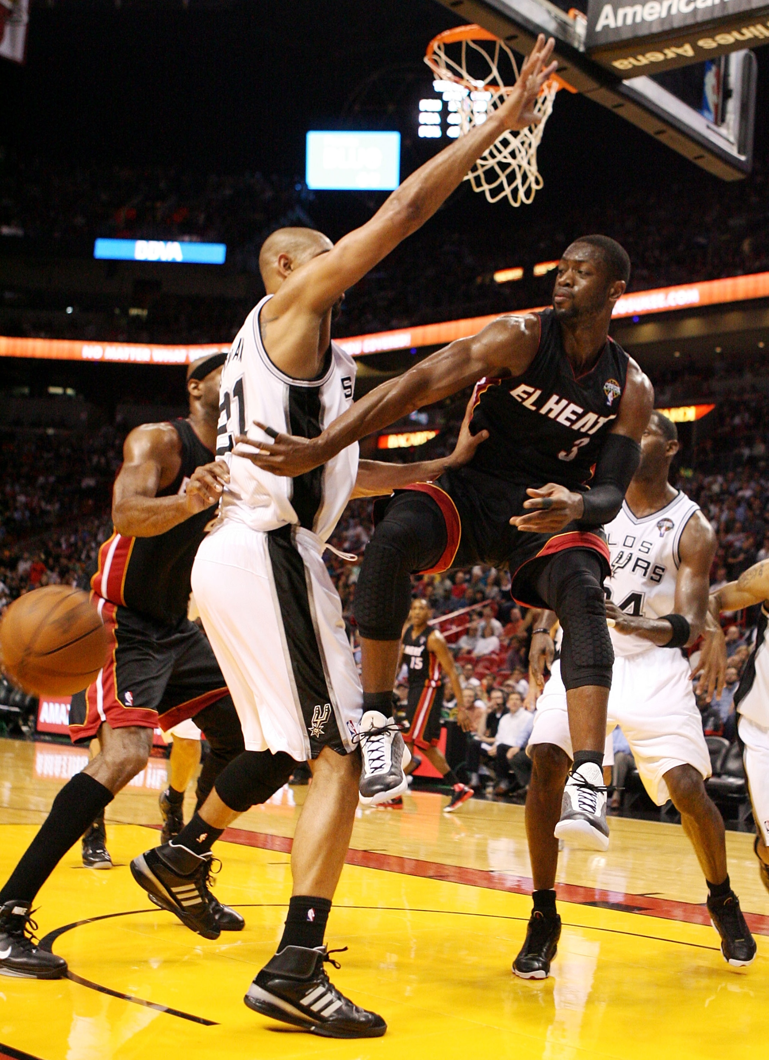 MIAMI - MARCH 14:  Guard Dwyane Wade #3 of the Miami Heat passes  against Center Tim Duncan #21 of the San Antonio Spurs at American Airlines Arena on March 14, 2011 in Miami, Florida. NOTE TO USER: User expressly acknowledges and agrees that, by download