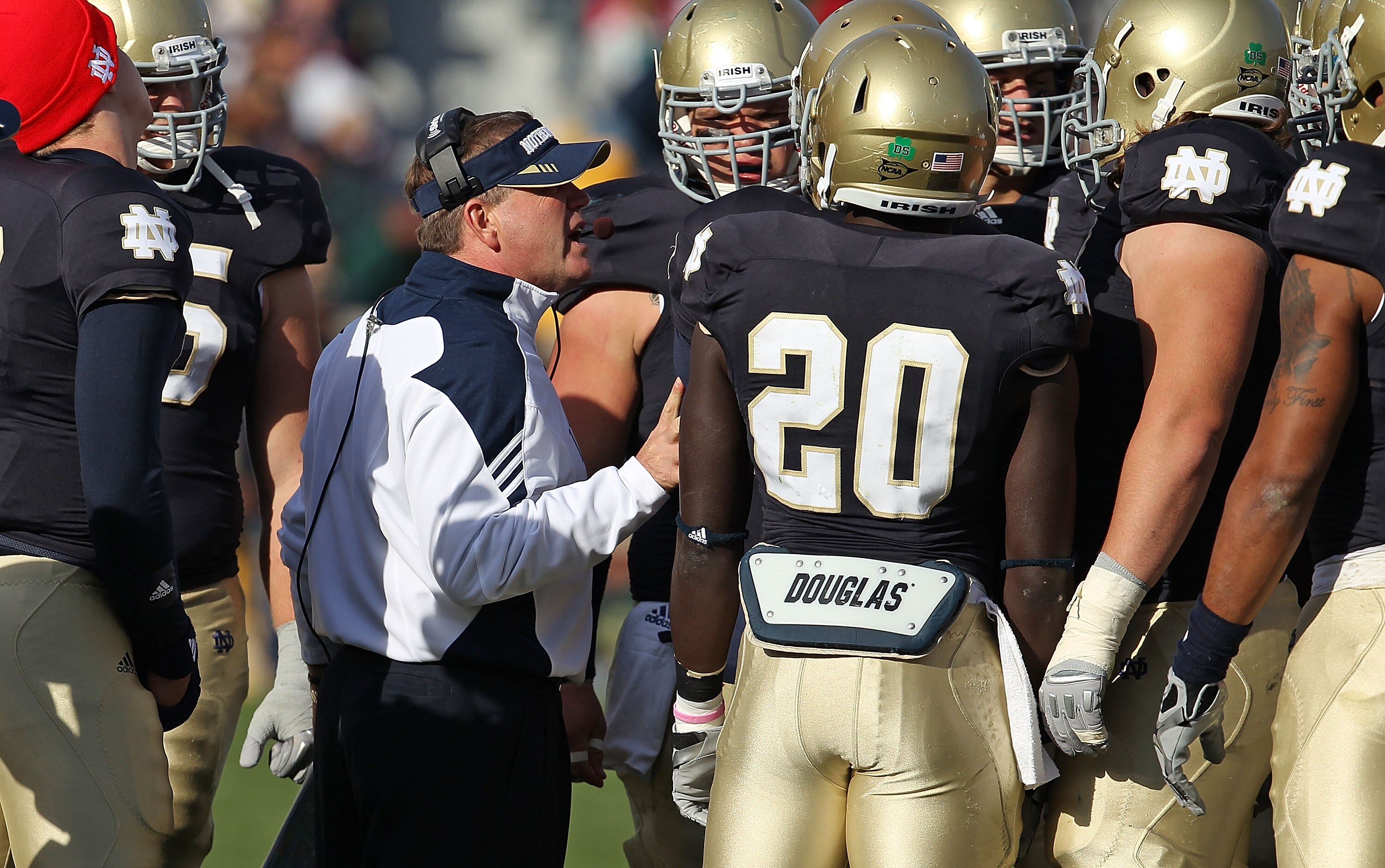 SOUTH BEND, IN - OCTOBER 30: Head coach Brian Kelly of the Notre Dame Fighting Irish talks to his offensive team including Cierre Wood #20 during a time-out against the Tulsa Golden Hurricane at Notre Dame Stadium on October 30, 2010 in South Bend, Indian