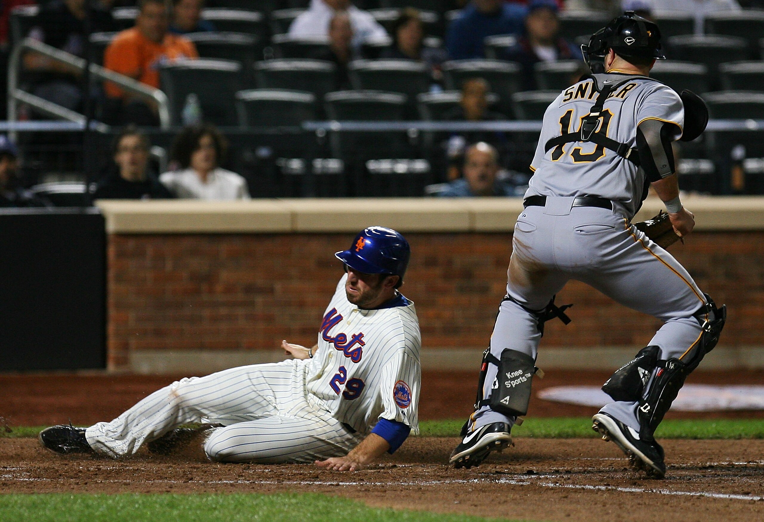 NEW YORK - SEPTEMBER 15:  Ike Davis #29 of the New York Mets slides safely into home while Chris Snyder #19 of the Pittsburgh Pirates watches in the fourth inning on September 15, 2010 at Citi Field in the Flushing neighborhood of the Queens borough of Ne