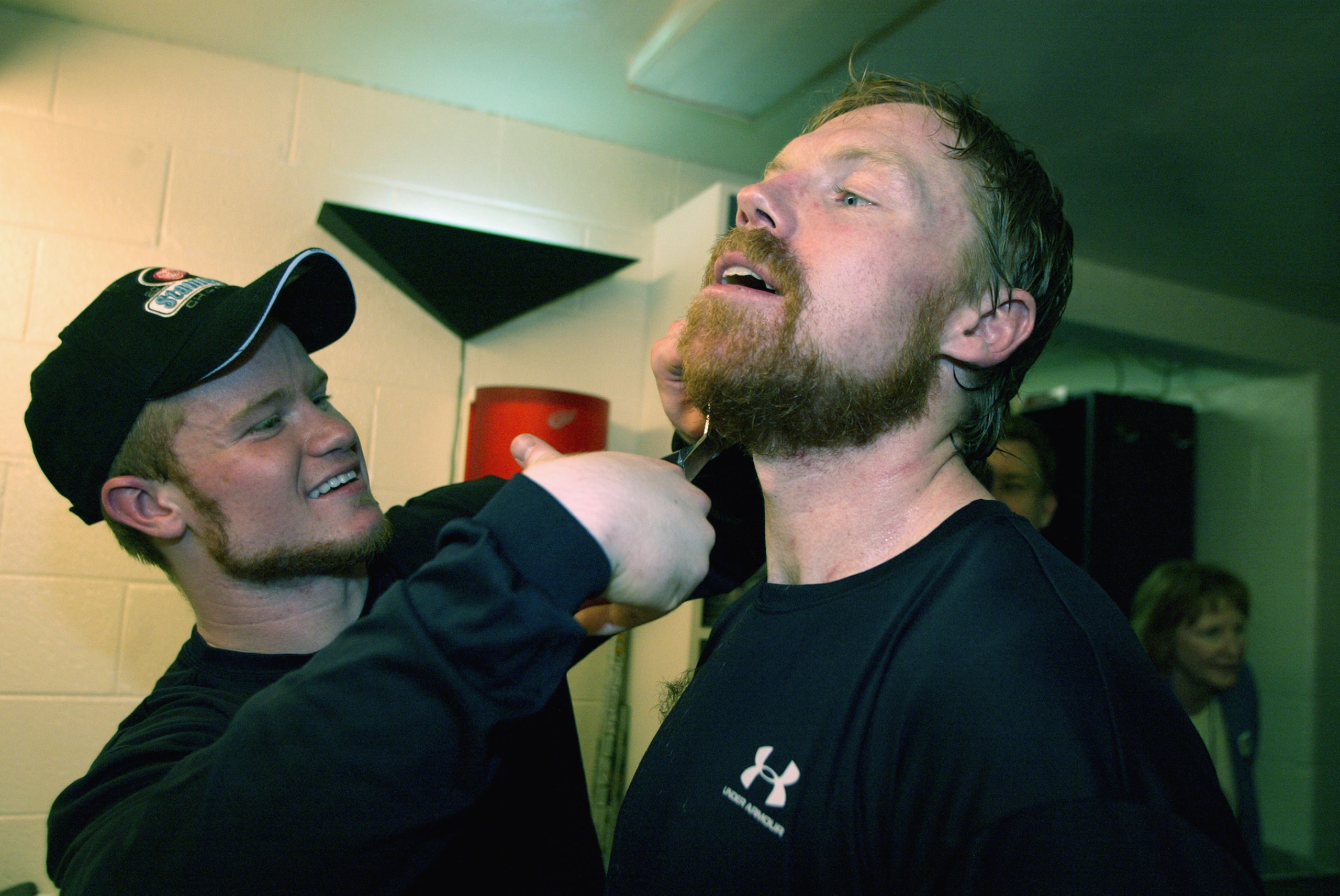 DETROIT, MI - JUNE 13:  Jason Williams #29 of the Detroit Red Wings cuts teammates Kris Draper's beard in the lockeroom after defeating the Carolina Hurricanes 3-1  and winning the Stanley Cup in game five of the NHL Stanley Cup Finals on June 13, 2002 at