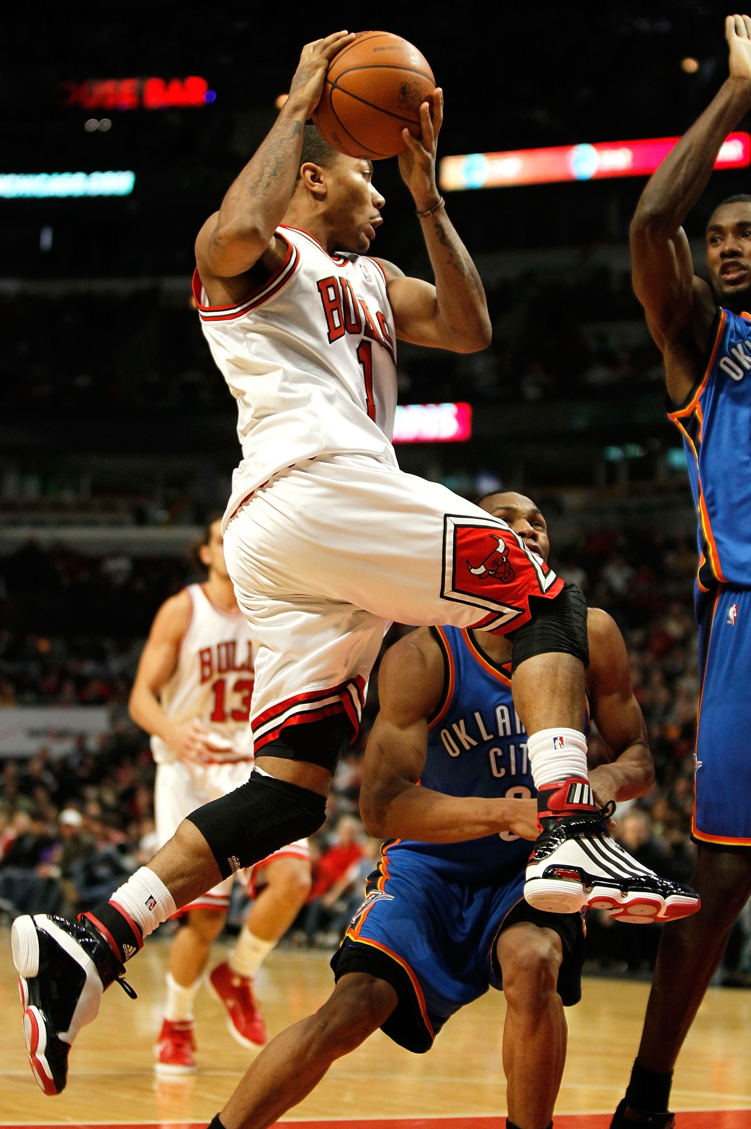 CHICAGO - JANUARY 04: Derrick Rose #1 of the Chicago Bulls leaps to pass against Russell Westbrook #0 and Serge Ibaka #9 of the Oklahoma City Thunder at the United Center on January 4, 2010 in Chicago, Illinois. The Thunder defeated the Bulls 98-85. NOTE