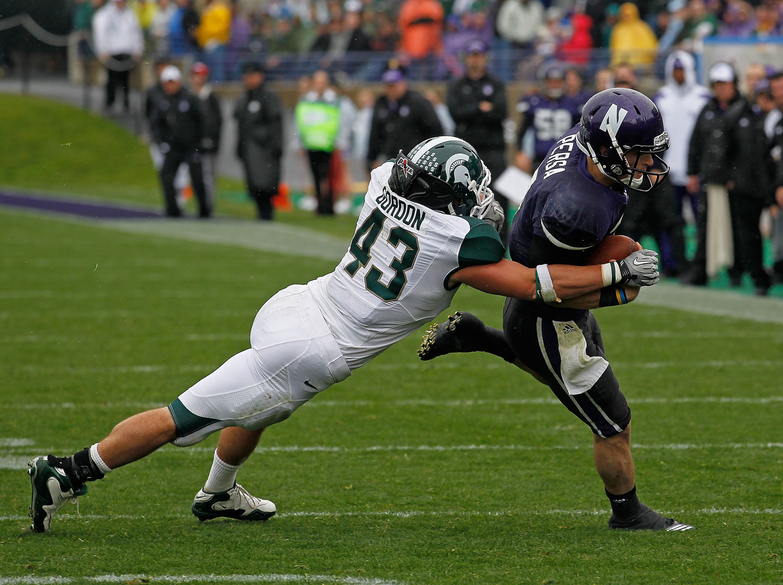 EVANSTON, IL - OCTOBER 23: Dan Persa #7 of the Northwestern Wildcats escapes a tackle attempt by Eric Gordon #43 of the Michigan State Spartans at Ryan Field on October 23, 2010 in Evanston, Illinois. Michigan State defeated Northwestern 35-27.  (Photo by