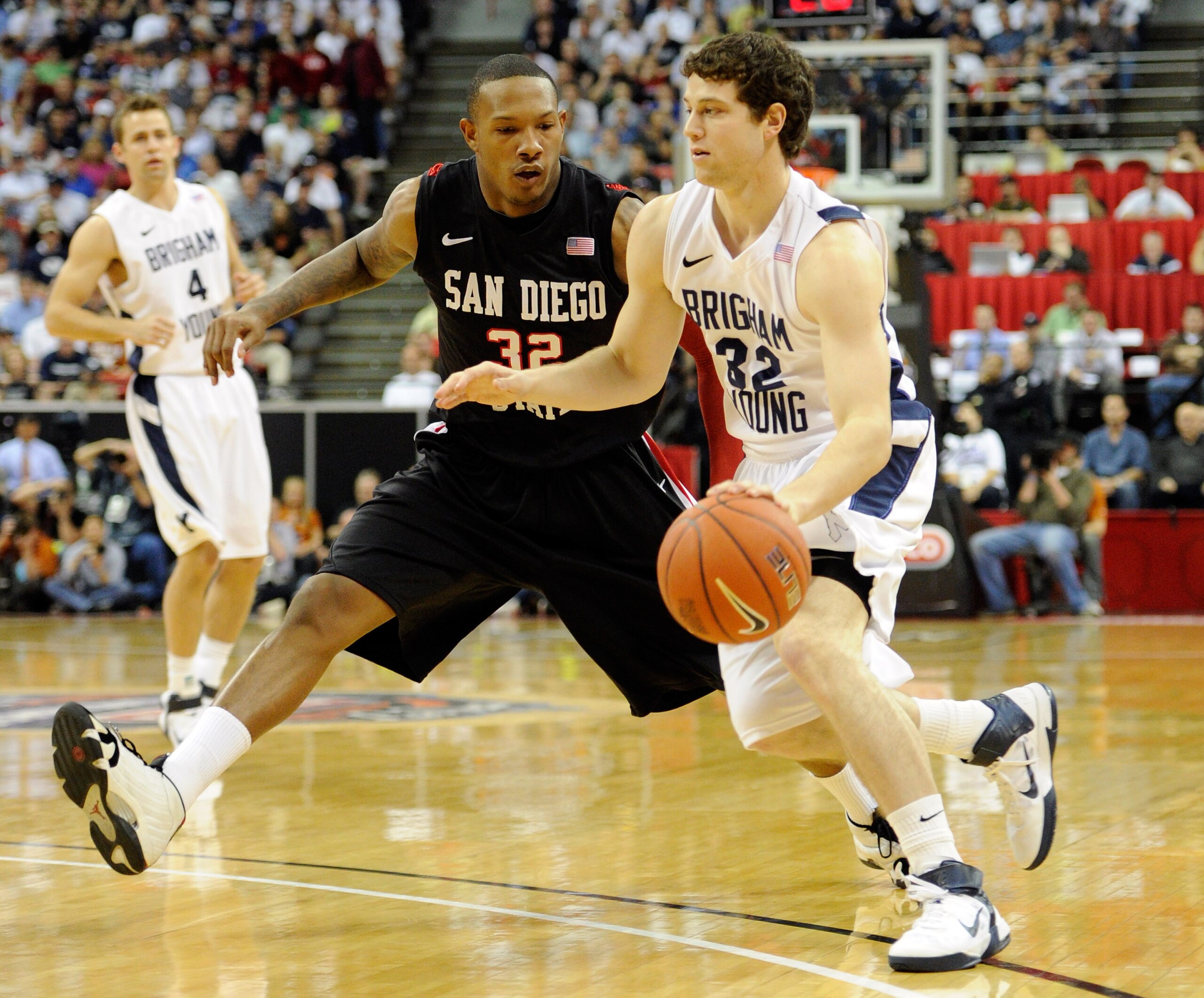 LAS VEGAS, NV - MARCH 12:  Jimmer Fredette #32 of the Brigham Young University Cougars drives against Billy White #32 # of the San Diego State Aztecs during the championship game of the Conoco Mountain West Conference Basketball tournament at the Thomas &