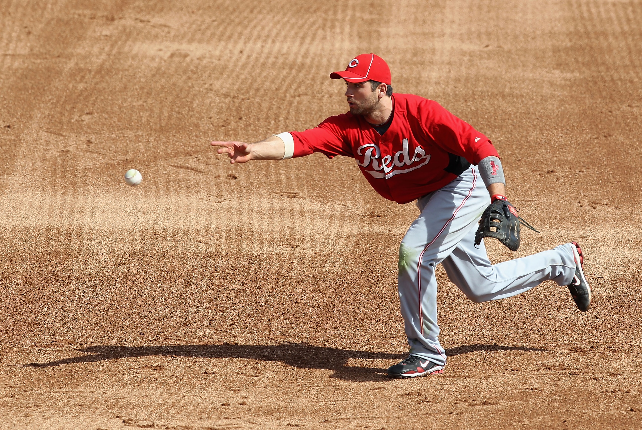 GLENDALE, AZ - MARCH 05:  Infielder Joey Votto #19 of the Cincinnati Reds fields a ground ball out against the Los Angeles Dodgers during the spring training game at Camelback Ranch on March 5, 2011 in Glendale, Arizona.  (Photo by Christian Petersen/Gett
