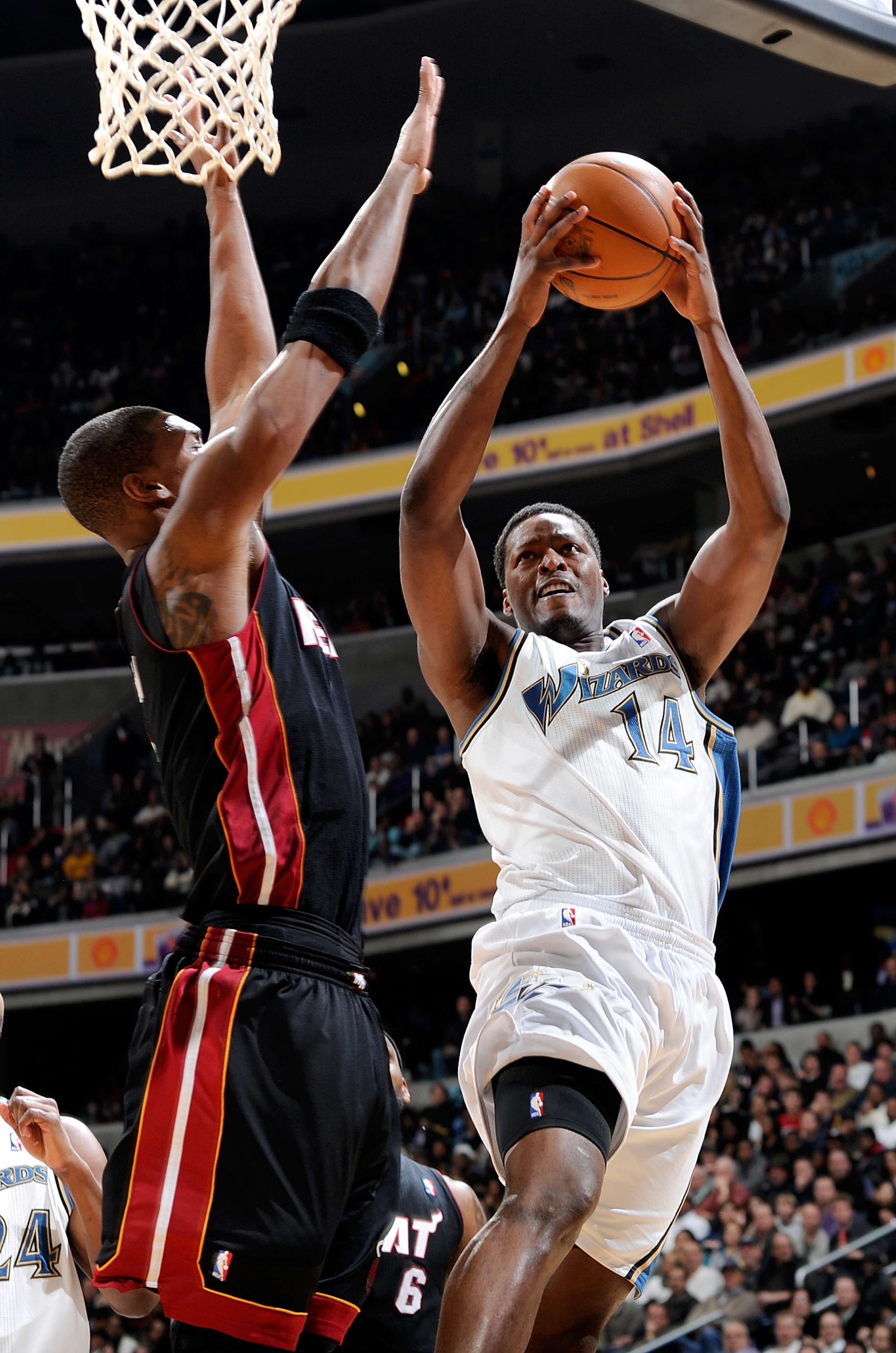 WASHINGTON, DC - DECEMBER 18:  Al Thornton #14 of the Washington Wizards drives to the hoop against Chris Bosh #1 of the Miami Heat at the Verizon Center on December 18, 2010 in Washington, DC. NOTE TO USER: User expressly acknowledges and agrees that, by