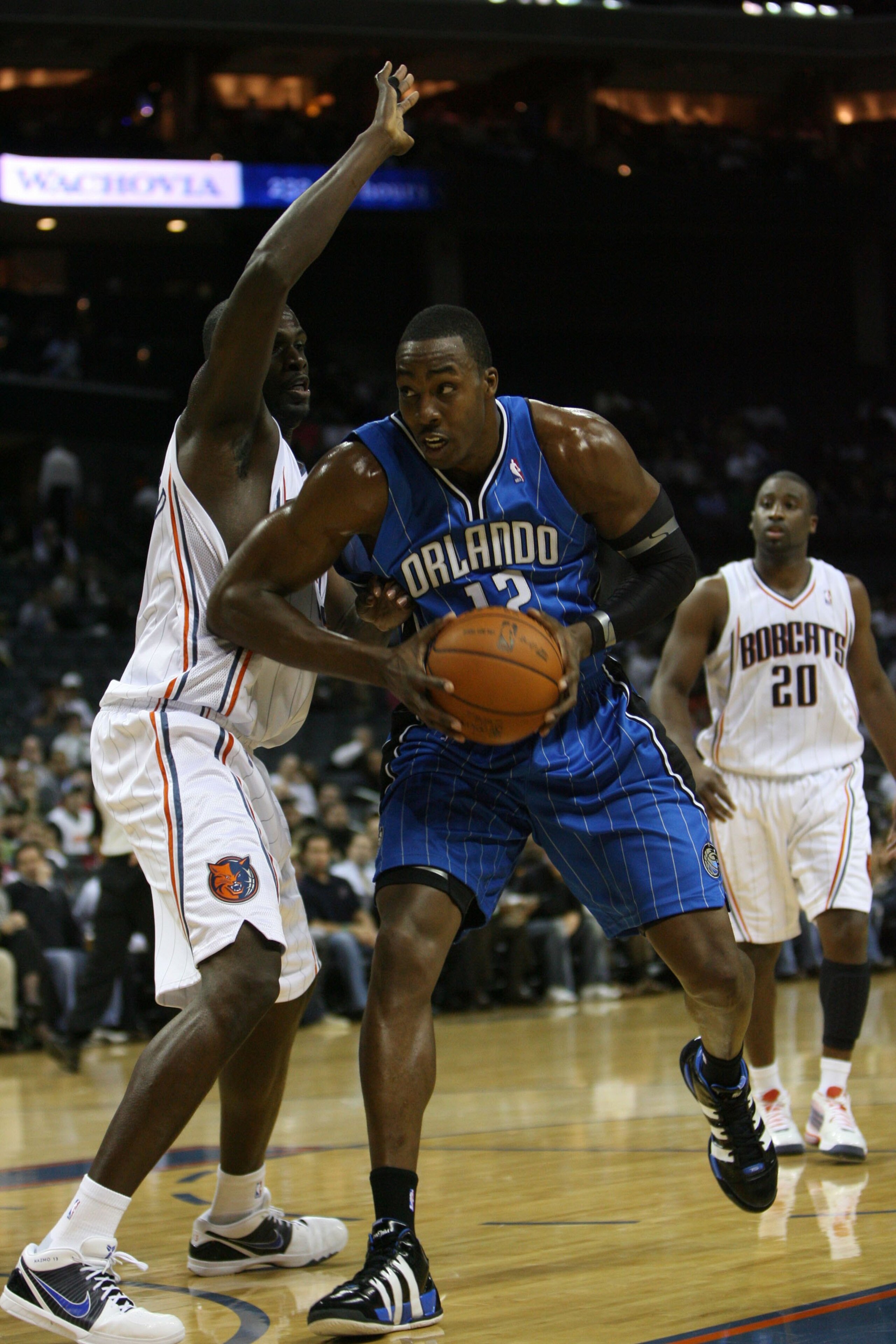 CHARLOTTE, NC - NOVEMBER 10:  Dwight Howard #12 of the Orlando Magic drives past Nazr Mohammed #13 of the Charlotte Bobcats during the game on November 10, 2009 at Time Warner Cable Arena in Charlotte, North Carolina.  The Magic won 93-81.  NOTE TO USER: