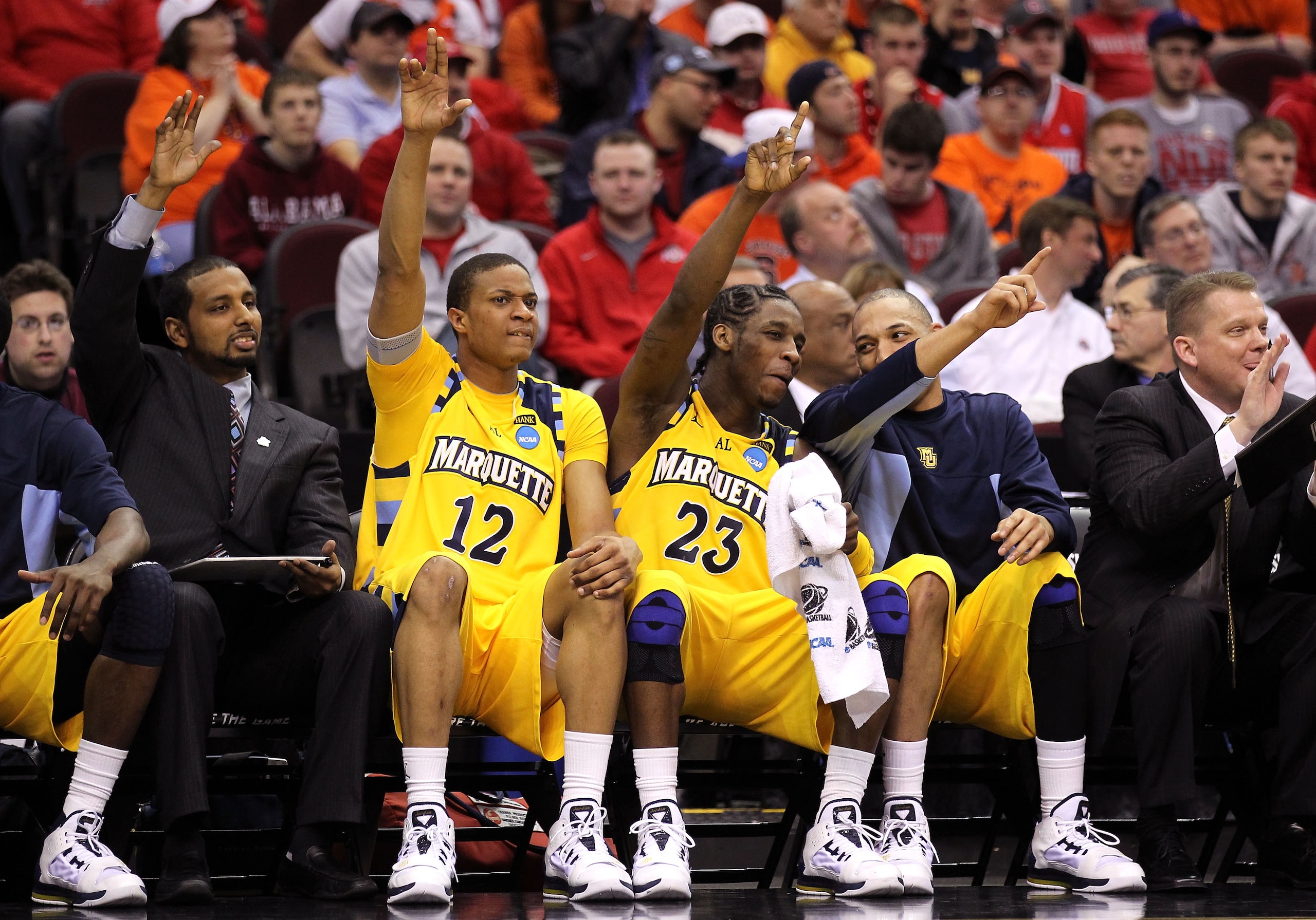 CLEVELAND, OH - MARCH 20: Erik Williams #12 and Dwight Buycks #23 of the Marquette Golden Eagles put their hands up with teammates while on the bench against the Syracuse Orange during the third of the 2011 NCAA men's basketball tournament at Quicken Loan