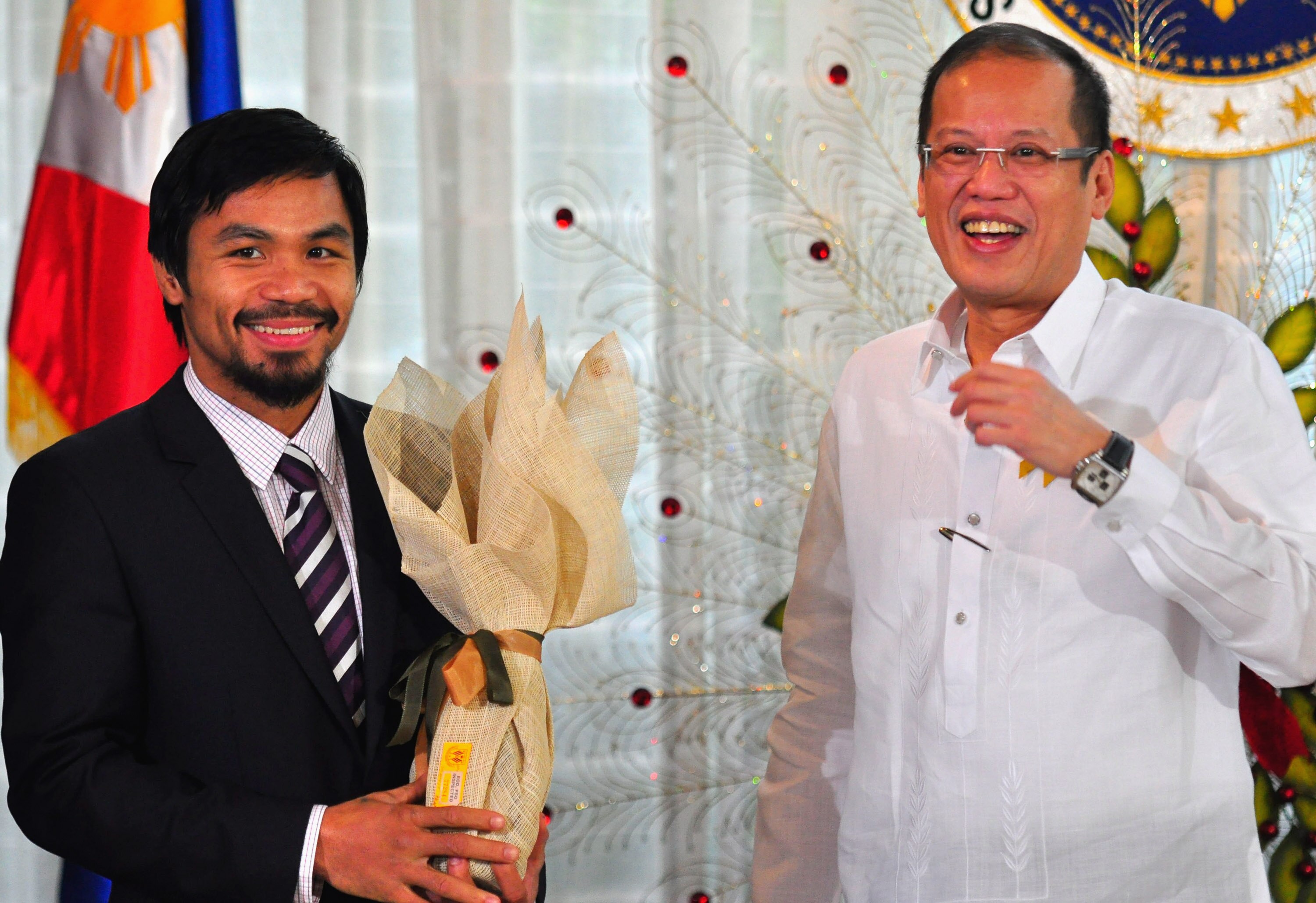 MANILA, PHILIPPINES - NOVEMBER 20:  Boxer and congressman, Manny Pacquiao recieves a gift from Philippine President Benigno Aquinoo III at Malacanang Palace in Manila following his win of the WBC super welterweight crown against Mexican Antonio Margarito
