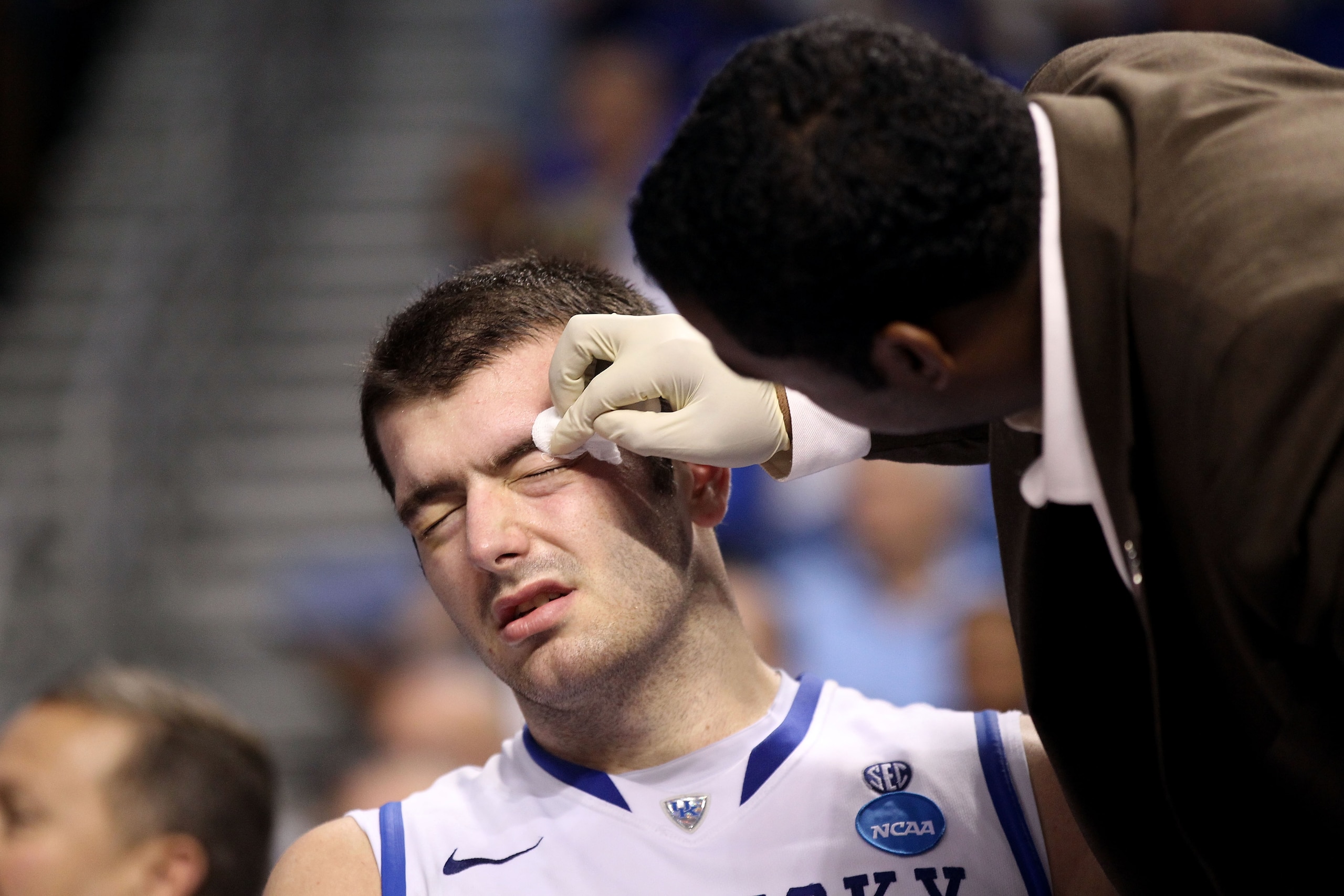 TAMPA, FL - MARCH 19:  Josh Harrellson #55 of the Kentucky Wildcats has a cut over his left eye treated by the trainer against the West Virginia Mountaineers during the third round of the 2011 NCAA men's basketball tournament at St. Pete Times Forum on Ma