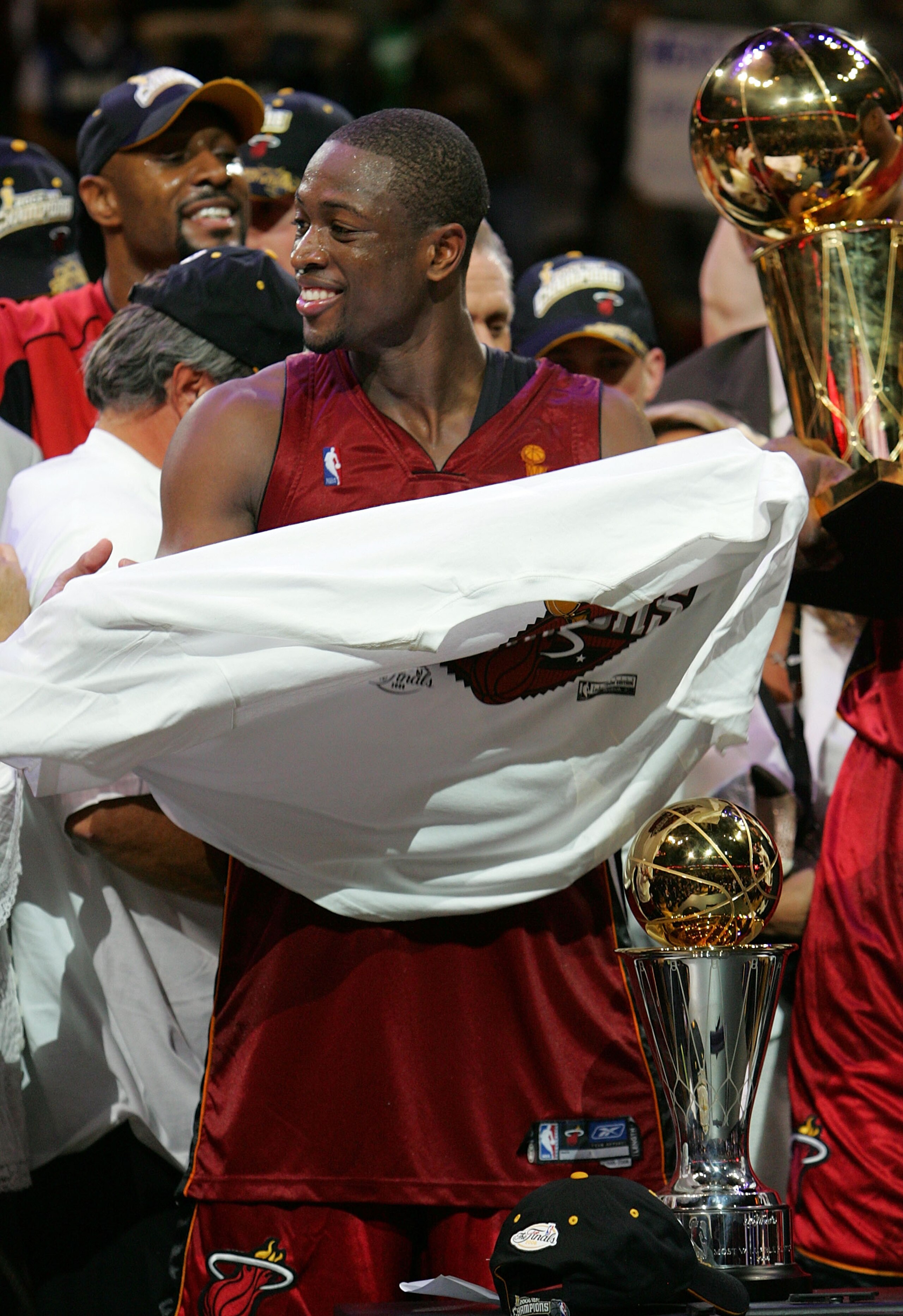 DALLAS - JUNE 20:  Dwyane Wade #3 of the Miami Heat puts on the championship t-shirt after game six of the 2006 NBA Finals on June 20, 2006 at American Airlines Center in Dallas, Texas. The Heat defeated the Mavericks 95-92 to win the NBA title.  NOTE TO